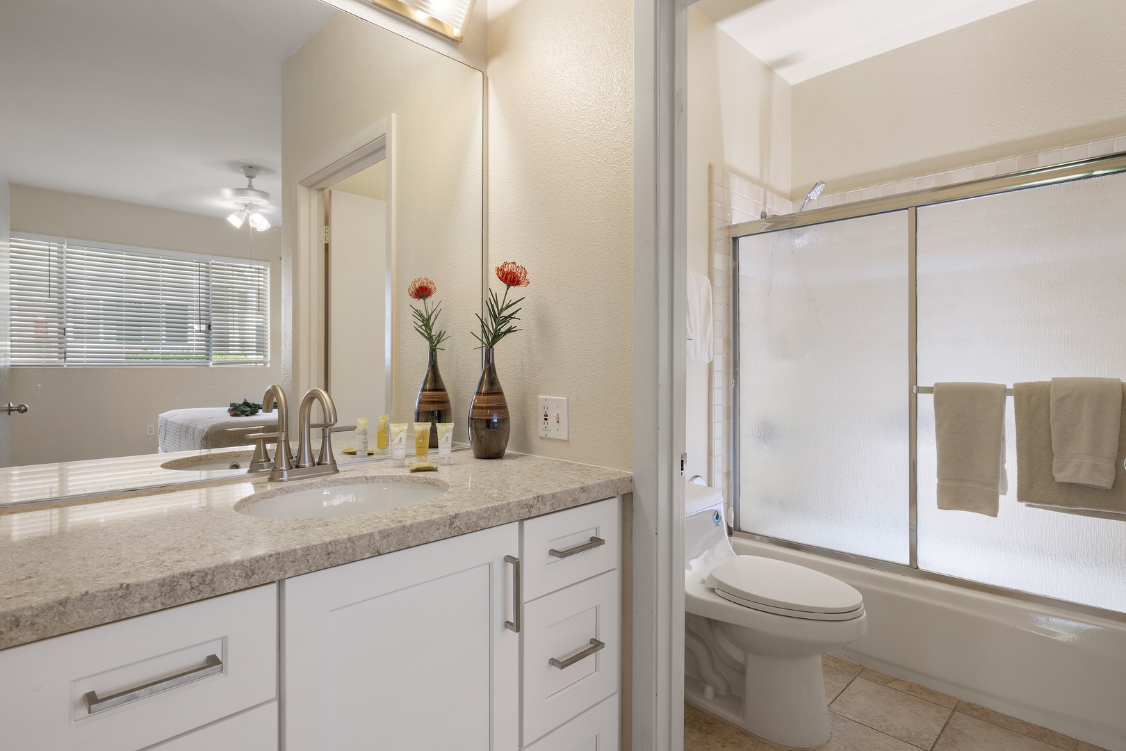 Your pristine bathroom features elegant granite counters, fresh florals, and a relaxing tub-shower combo for unwinding after busy travel days.