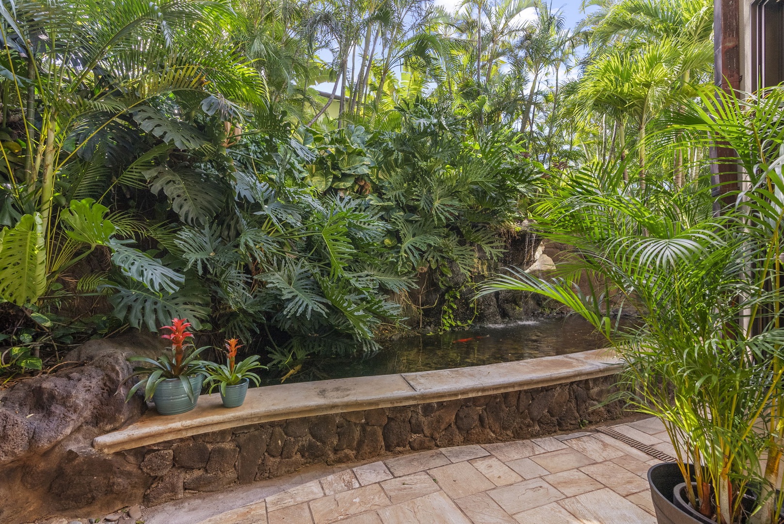 Honolulu Vacation Rentals, Pili Pono - Serene garden pathway with vibrant plants and cozy seating area.