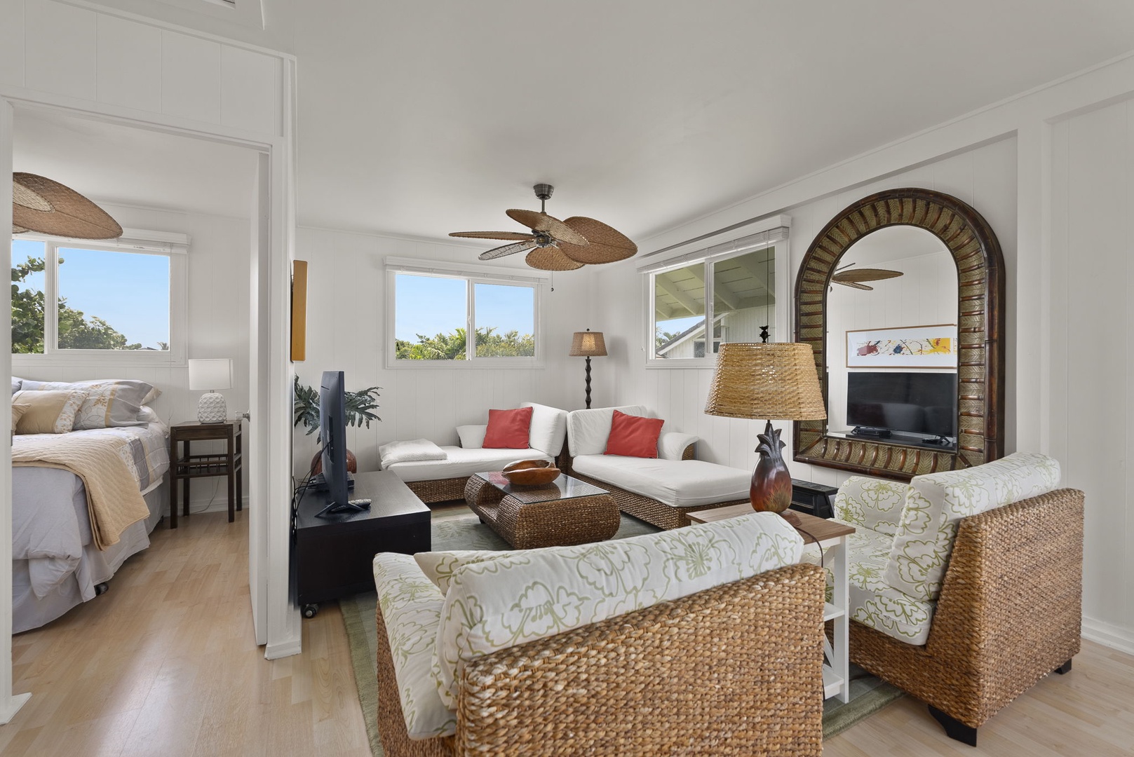 Waianae Vacation Rentals, Ma'ili Blue Estate - Relax in your tropical-inspired living area at the cottage with wicker furnishings, coral accents, and natural light flowing through multiple windows.