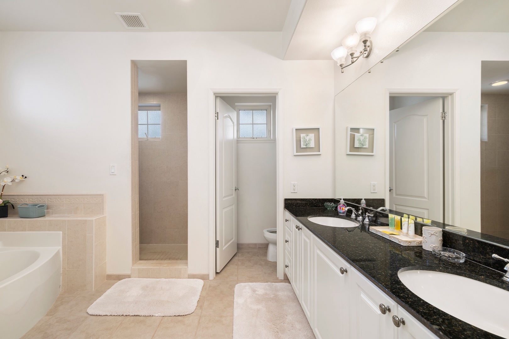 Your spacious bathroom features dual vanities, elegant marble tiling, and a relaxing soaking tub for unwinding after your adventures.