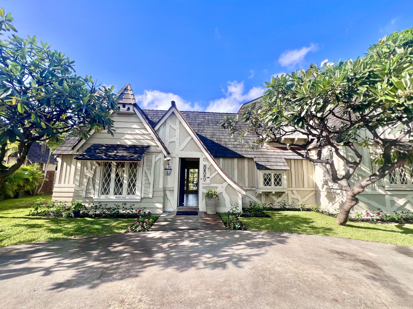 Honolulu Vacation Rentals, Kahala Palms - Charming cottage-style home with beautiful landscaping and mature trees, creating a picturesque and welcoming entrance.