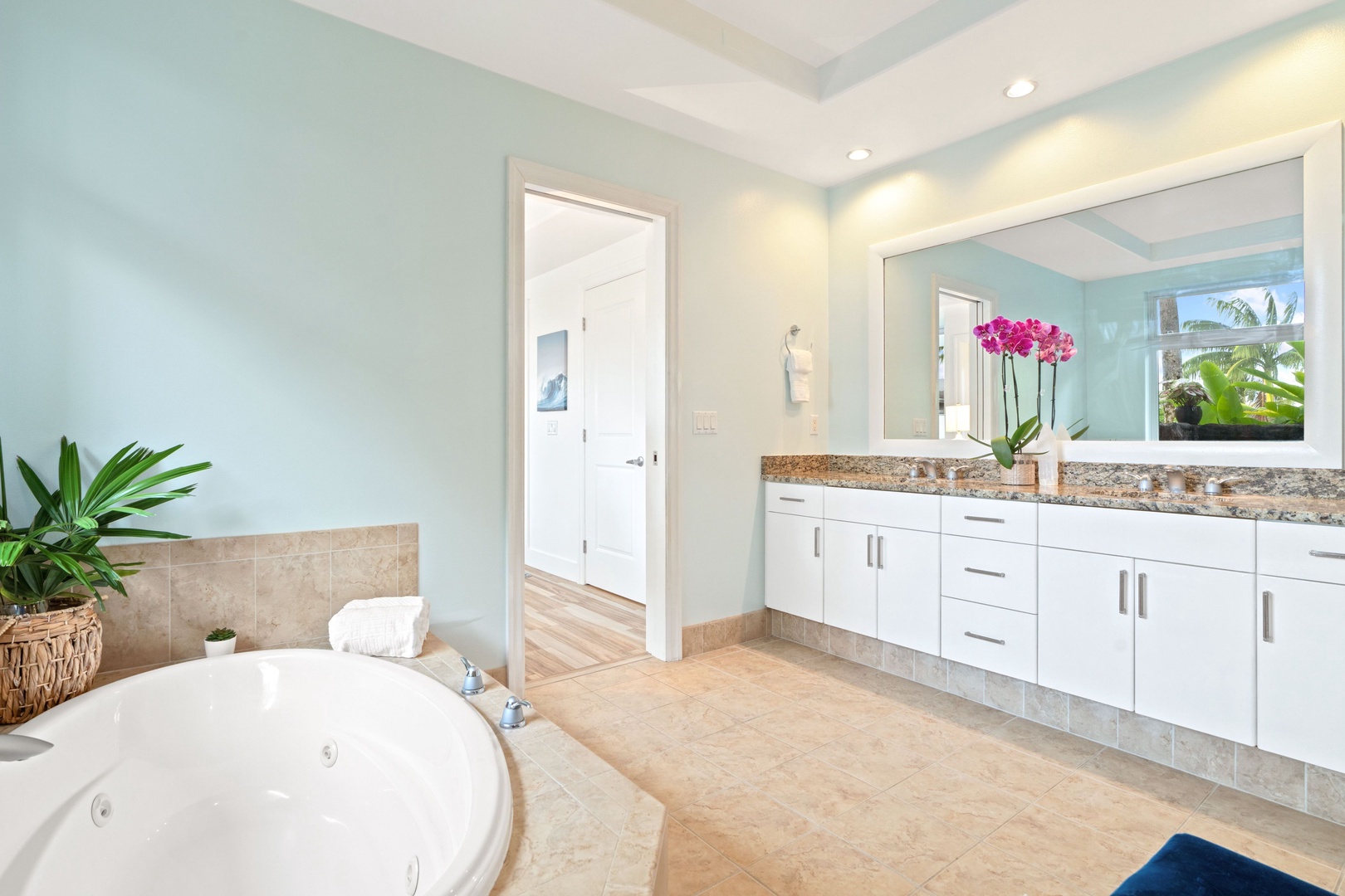 Princeville Vacation Rentals, Tropical Elegance - Step into a tranquil ensuite bathroom painted in a calming shade of blue.