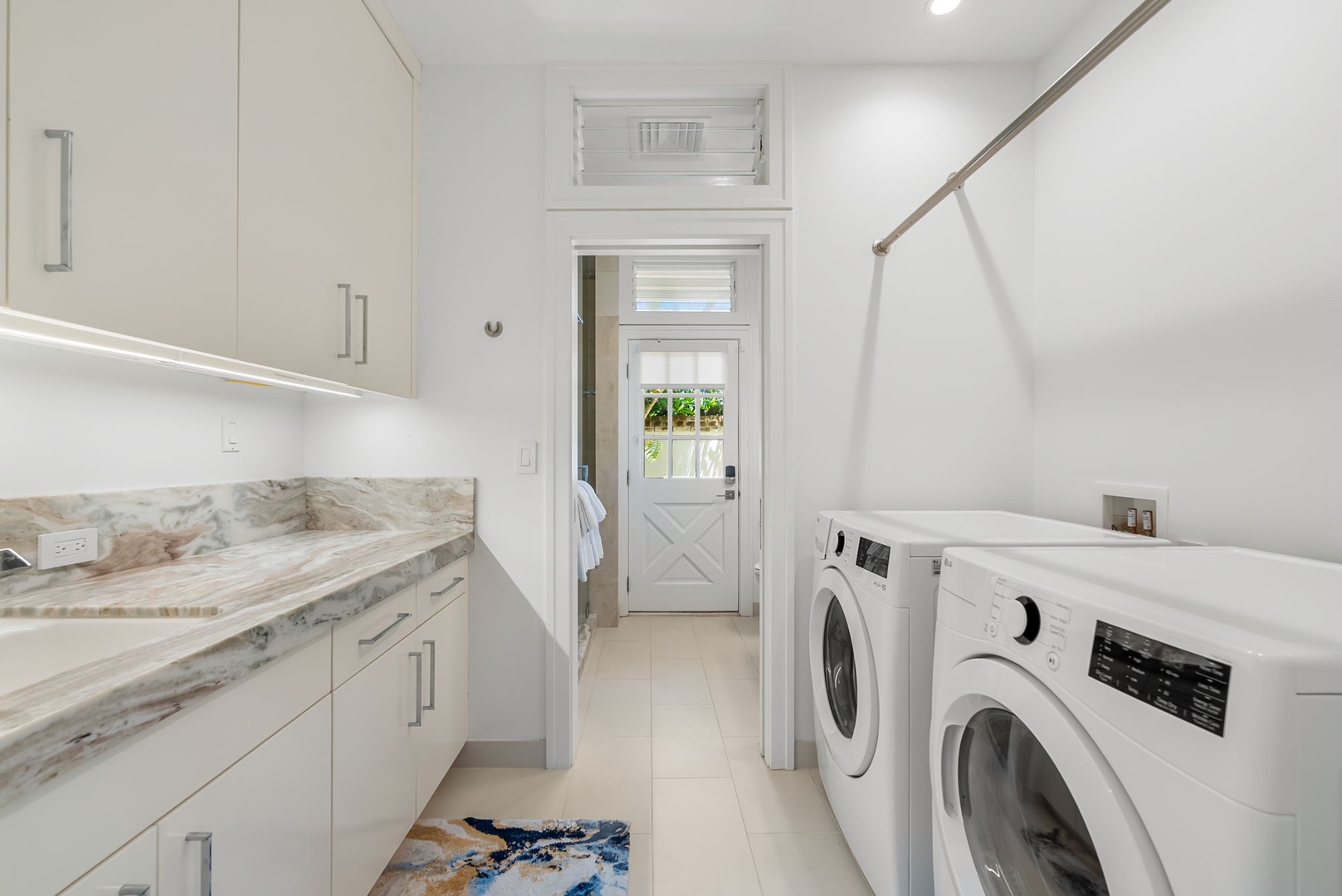 Kailua Vacation Rentals, Lanikai Sunrise - Hall bath with dual-purpose washer/dryer and polished marble finishes.