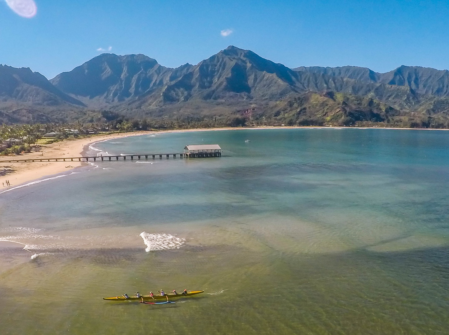 Princeville Vacation Rentals, Pohaku Kauai - Pristine bay with dramatic mountain backdrop, sandy beach, and crystal-clear waters perfect for kayaking and seaside relaxation.