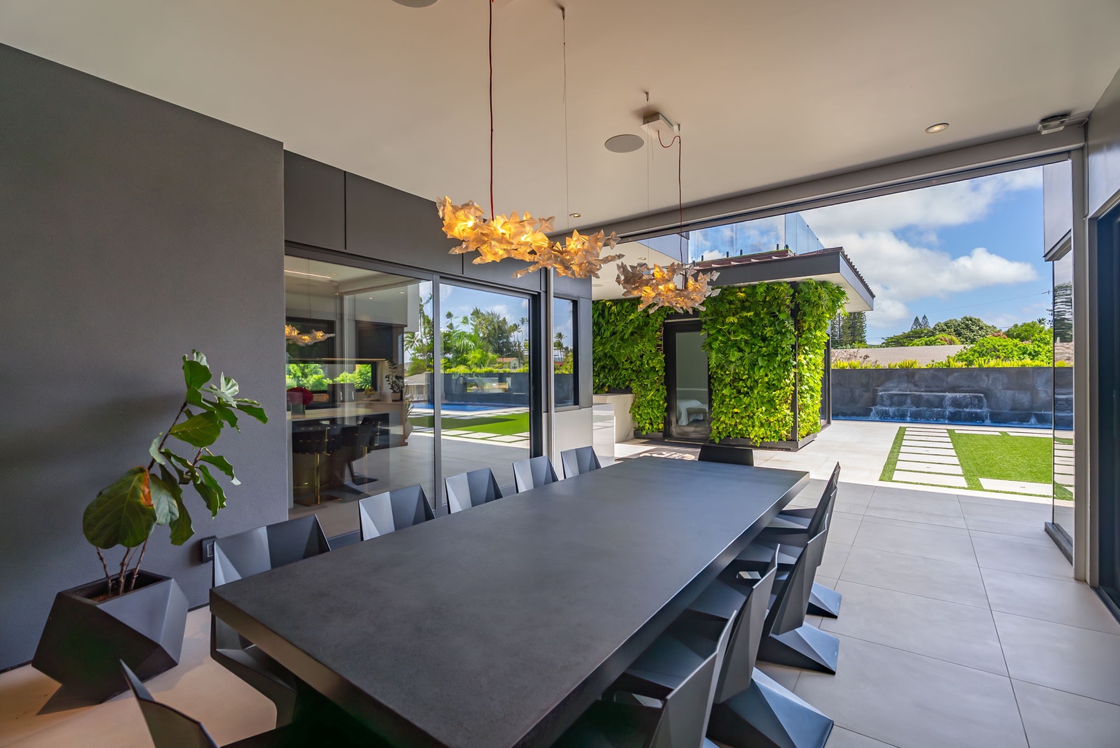 Honolulu Vacation Rentals, Ocean Villa Emilie - Dine al fresco under sculptural lighting, with views of green walls and ocean horizons just beyond.