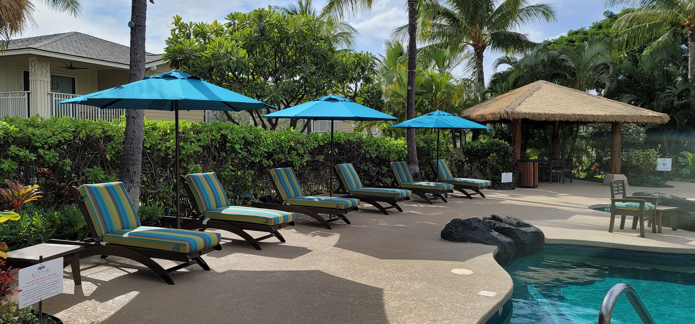 Kapolei Vacation Rentals, Ko Olina Kai 1097C - Loungers and cabanas by the pool, a perfect spot to share drinks while lounging.