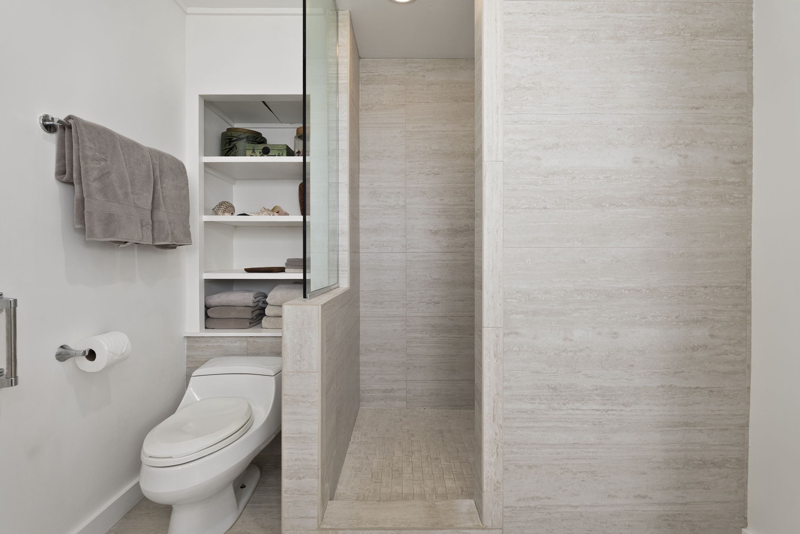 Waianae Vacation Rentals, Ma'ili Blue - This shared ensuite bathroom has sleek stone tiles, spacious walk-in shower, and thoughtful storage built right in.