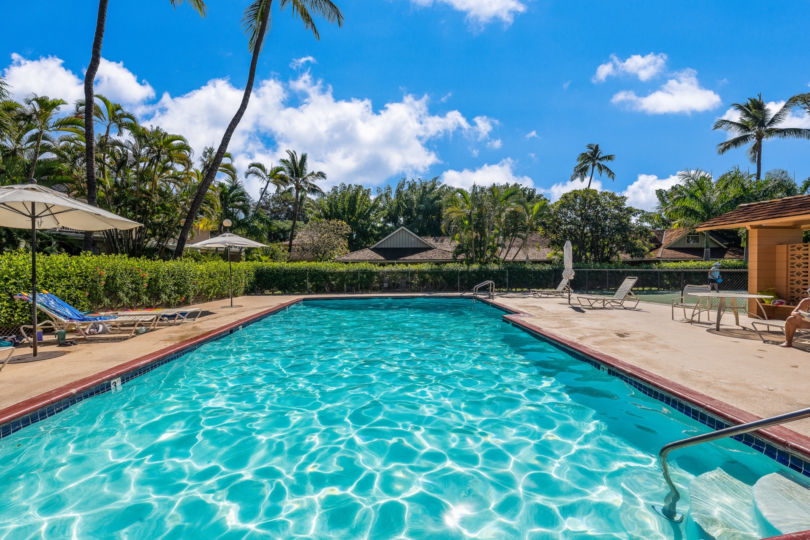 Lahaina Vacation Rentals, Puamana 254-2 - Puamana Resort's poolside seating area, surrounded by tropical flowers, creates a perfect sunny retreat.