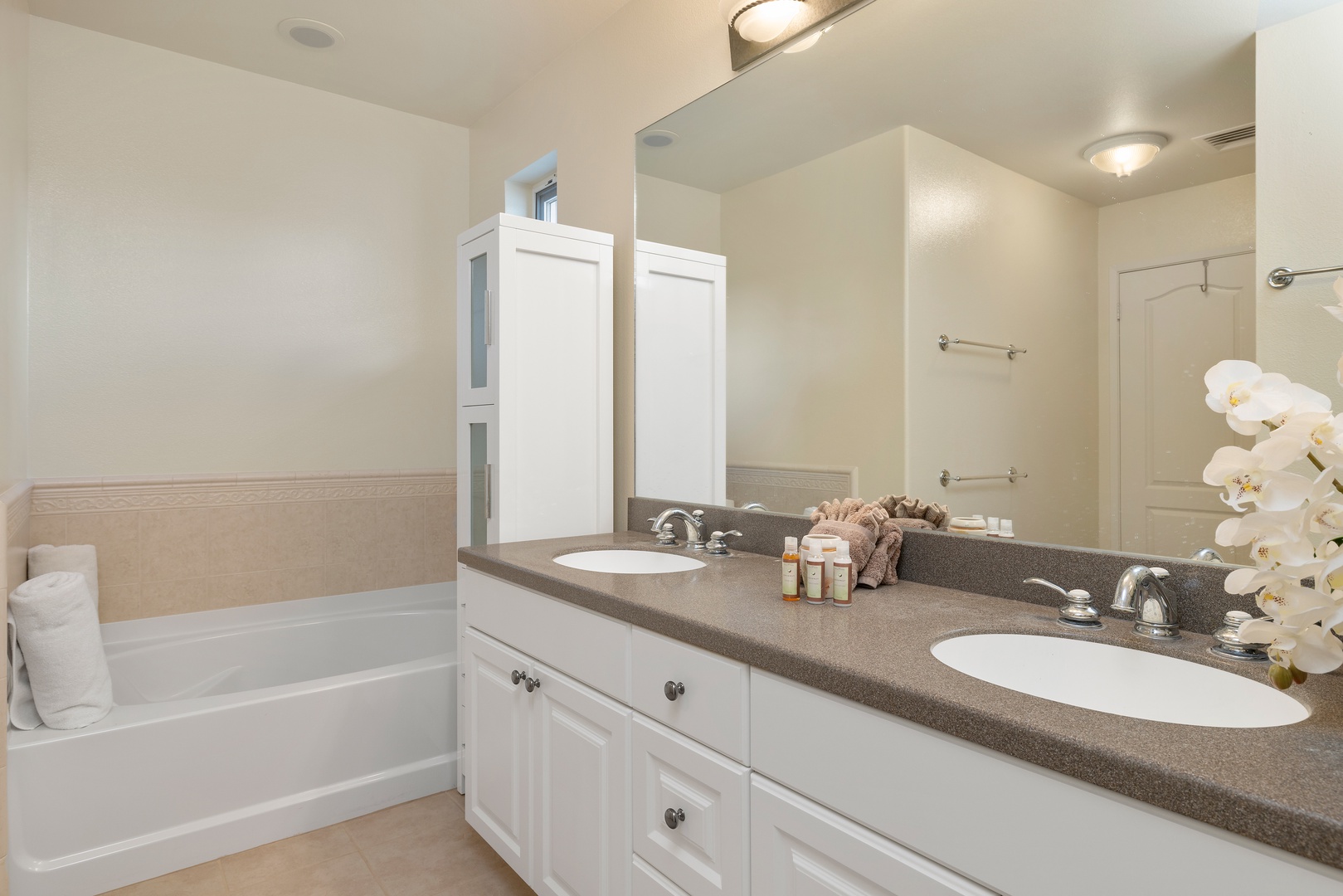 Kapolei Vacation Rentals, Ko Olina Kai 1083C - The primary guest bathroom with a walk-in shower, cabinetry and a soaking tub.