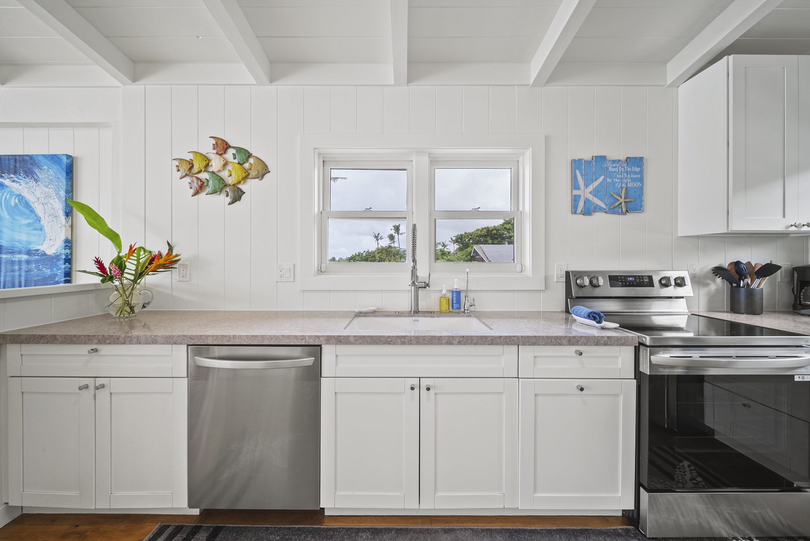 Haleiwa Vacation Rentals, Surfer's Paradise - Sunny kitchen workspace framed by tropical views, offering plenty of counter space for family-style cooking.