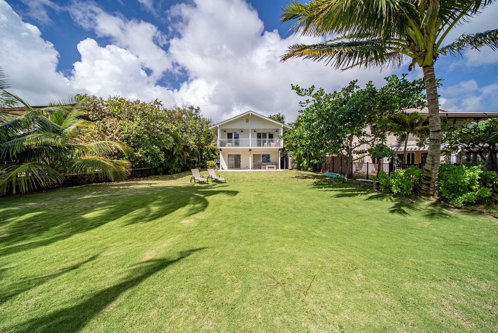 Honolulu Vacation Rentals, Honolulu Beachfront Retreat - Open lawn space framed by palm trees, offering plenty of room for family games, gatherings, or sun-soaked relaxation.