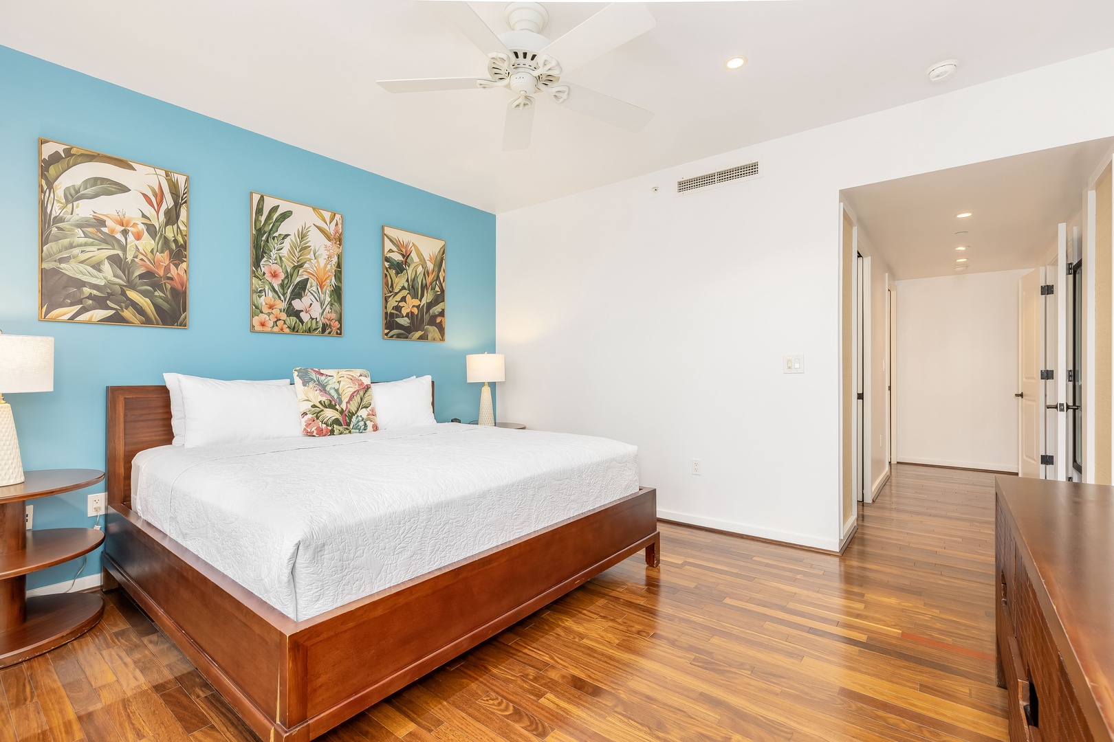 Kahuku Vacation Rentals, Turtle Bay Villas 209 - Unwind in your tropical-themed bedroom with crisp linens, vibrant artwork, and gleaming hardwood floors creating a serene retreat.