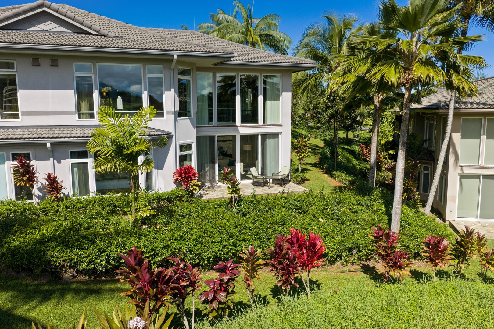 Princeville Vacation Rentals, Kaiulani #8 - Stand on the back lawn and the two-story glass reflects the palms right back.