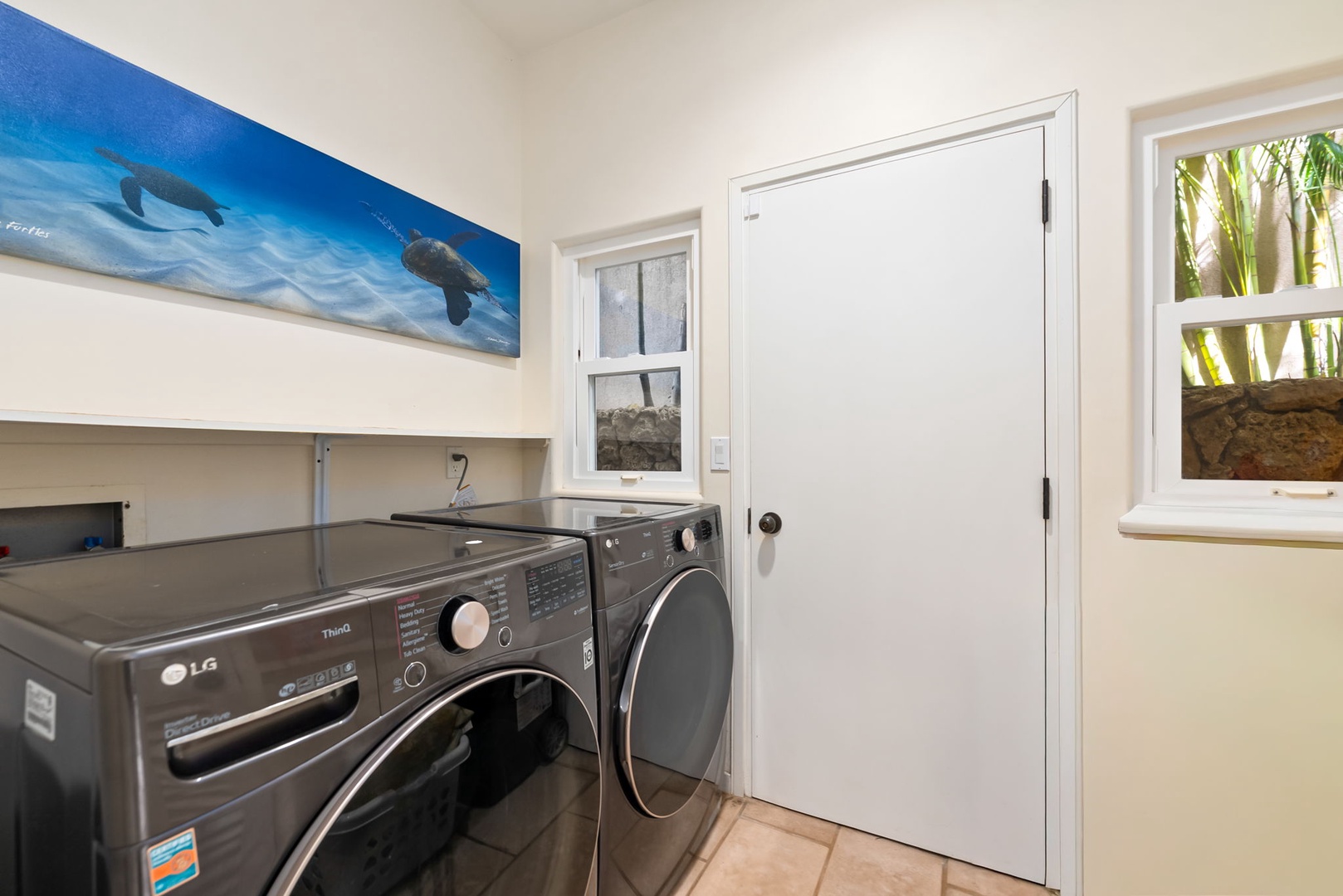 Honolulu Vacation Rentals, Diamond Head Luxe - Your dedicated laundry room keeps vacation clothes fresh with modern washer and dryer, plus cheerful ocean artwork brightening your daily routine.