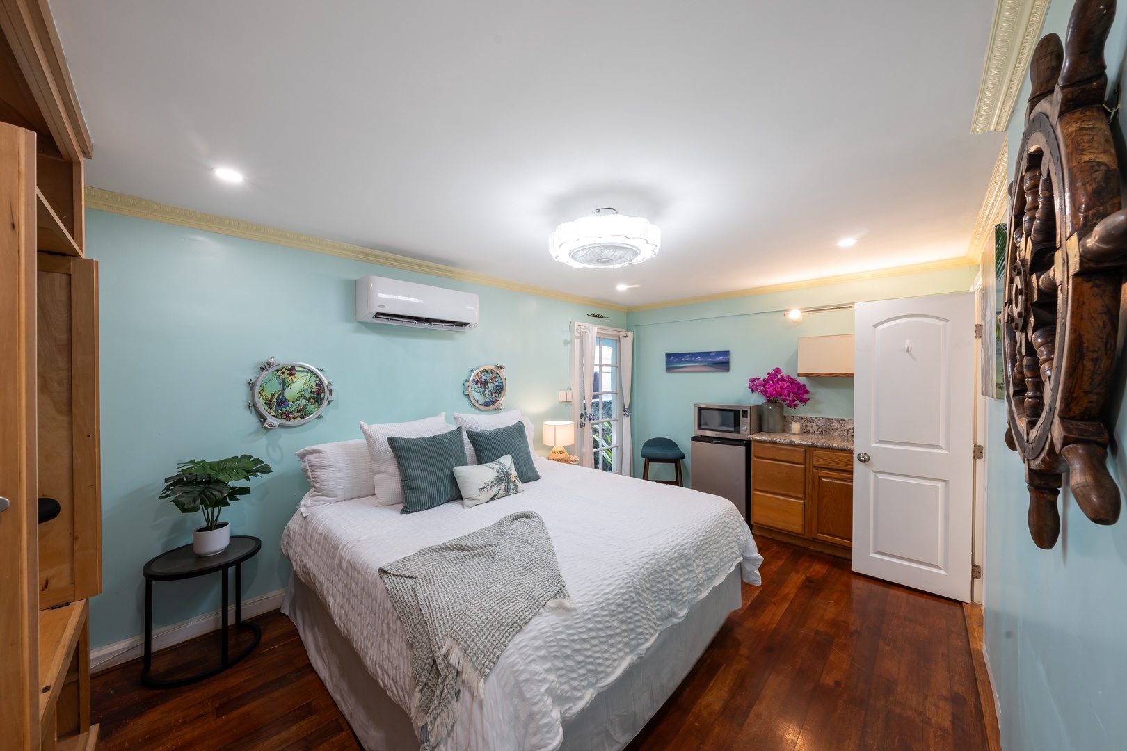 Hauula Vacation Rentals, Private Beach Paradise - Plush bedroom retreat with coastal tones, warm wood floors, and added kitchenette convenience.