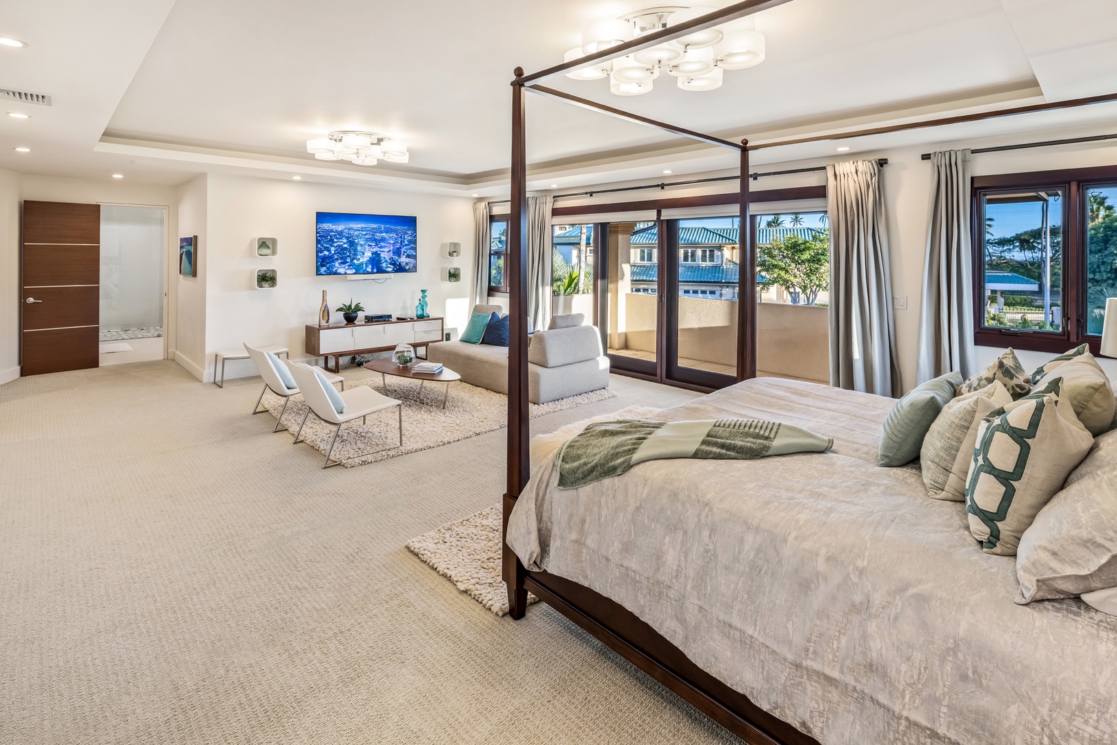 Honolulu Vacation Rentals, Kahala Grand Splendor - Elegant primary suite with a four-poster bed and the lounge area that provides a comfortable space to relax and recharge.