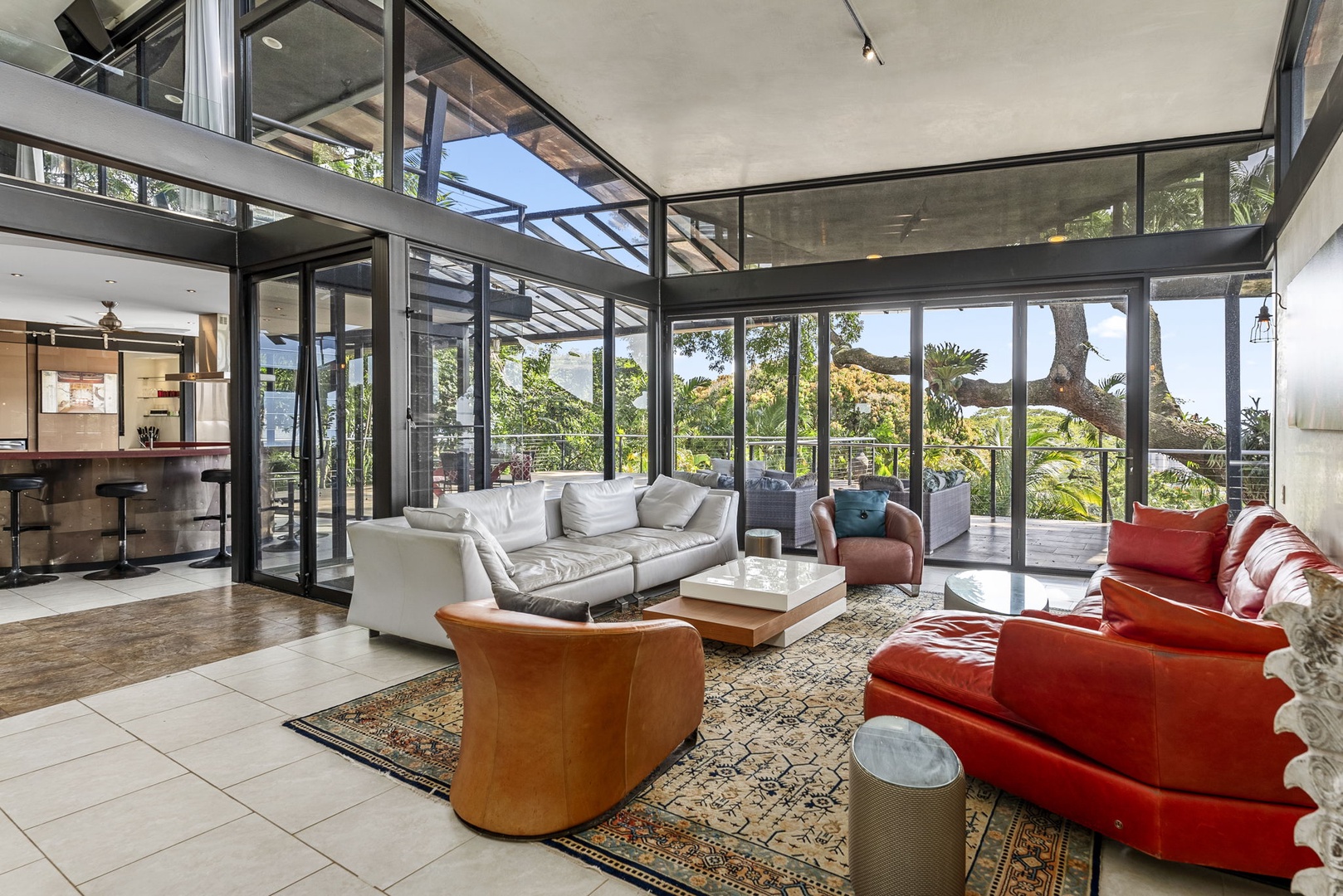Honolulu Vacation Rentals, Tantalus Glass House (3 BD) - Stunning glass-walled living room where floor-to-ceiling windows frame lush garden views and natural light floods your space.