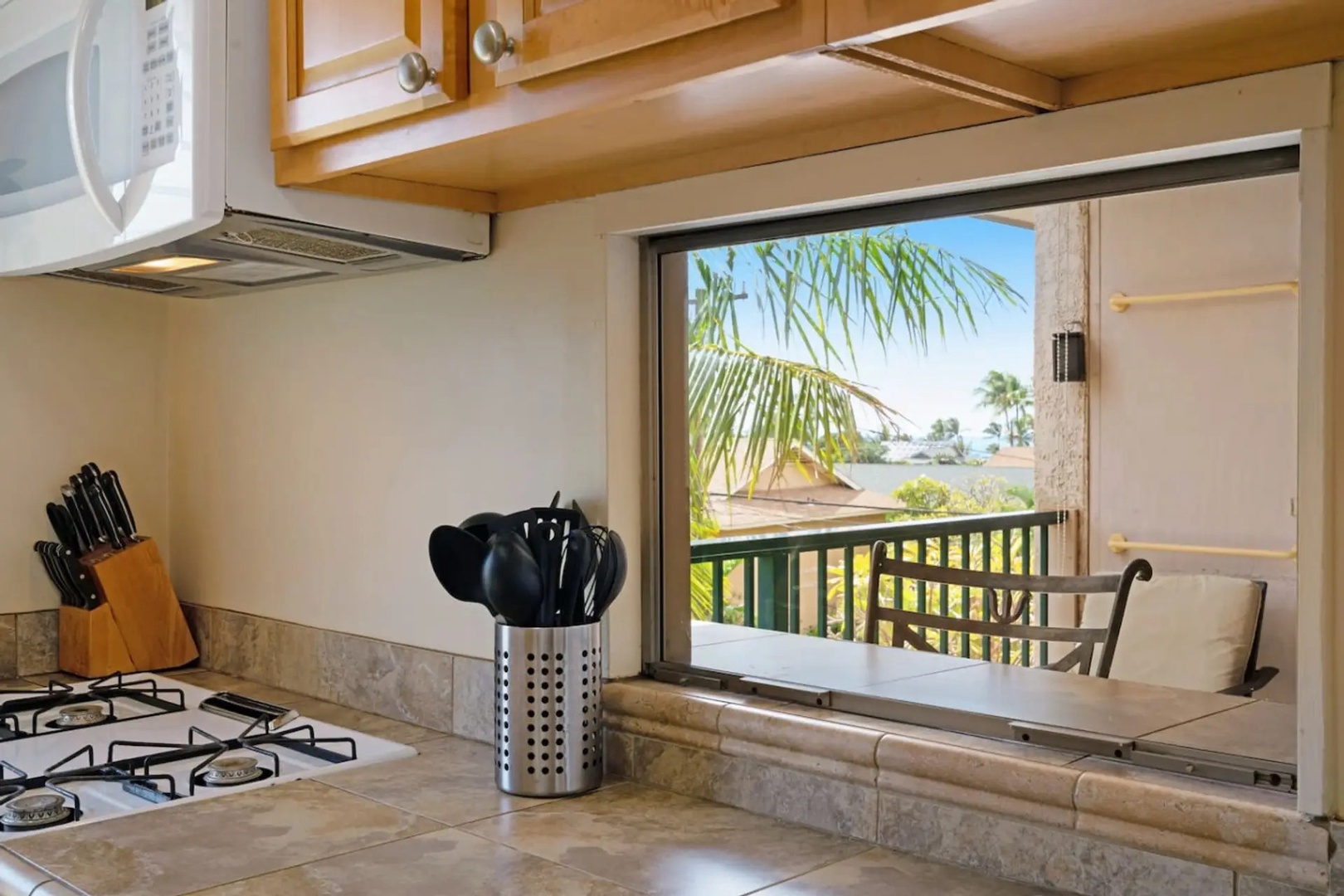 Kihei Vacation Rentals, Kalama Terrace P302 - Perch at the bar-height table or take a chair, either way the palm tree blocks the parking lot from view.