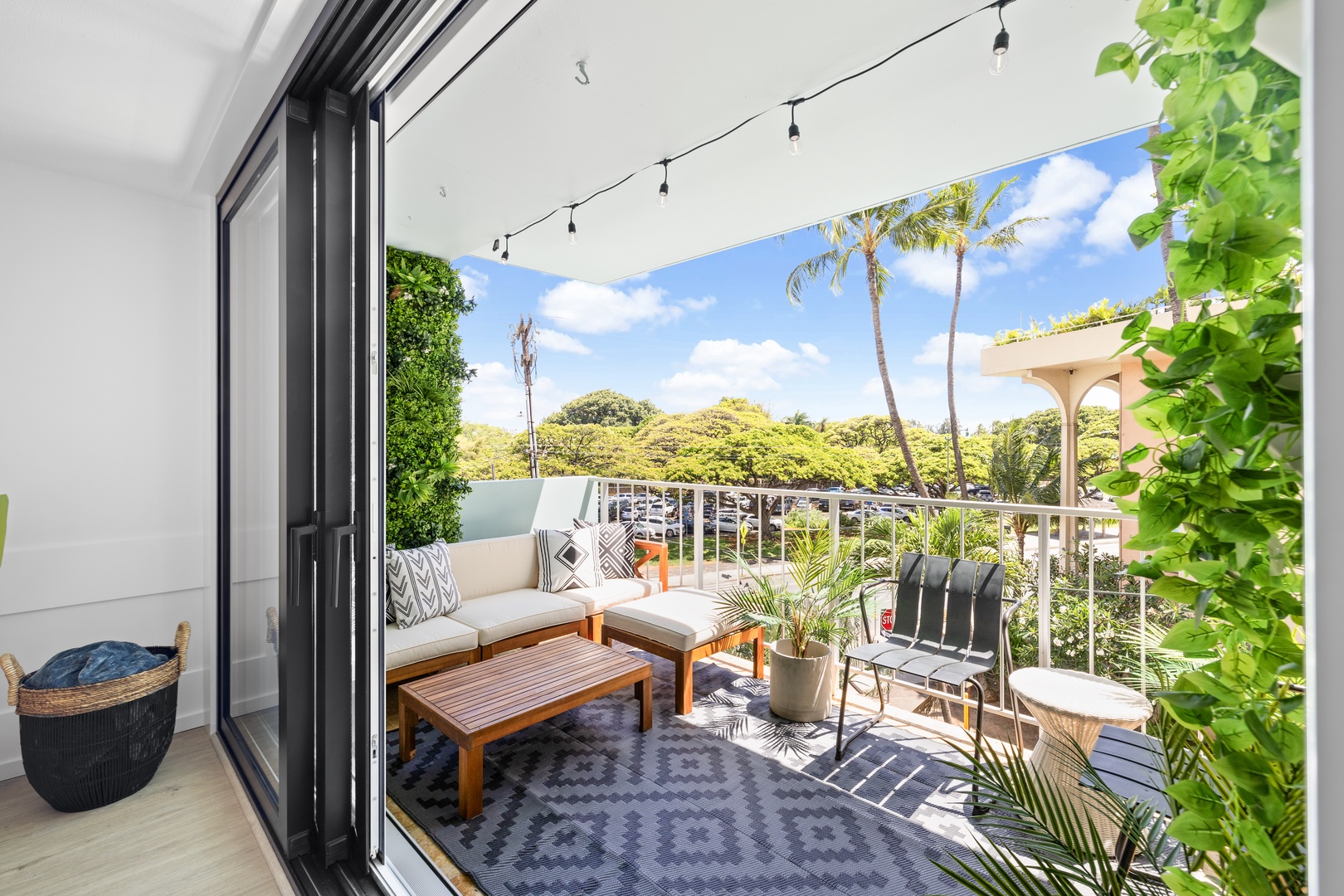 Honolulu Vacation Rentals, Hale Pono Waikiki - Enjoy a relaxing moment on this spacious lanai, complete with comfortable seating and a view of lush greenery.