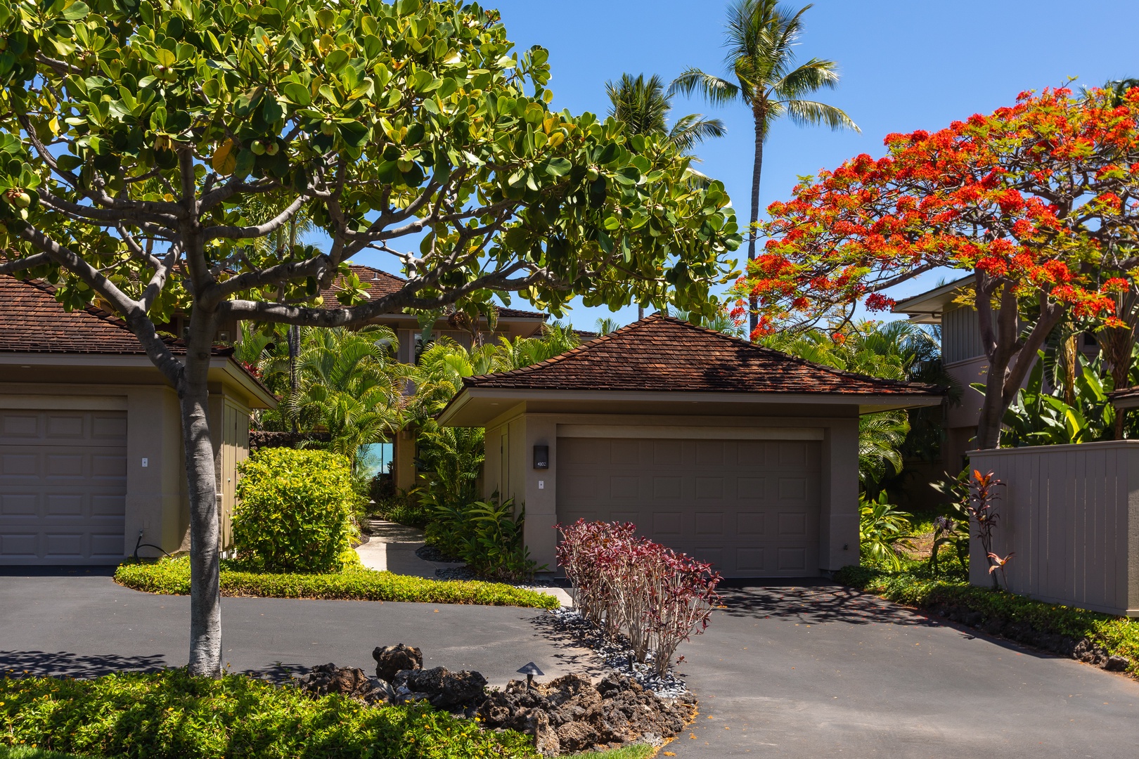Kailua Kona Vacation Rentals, 2BD Hillside Villa (4102) at Hualalai Resort - Private driveway and garage framed by vibrant tropical foliage.