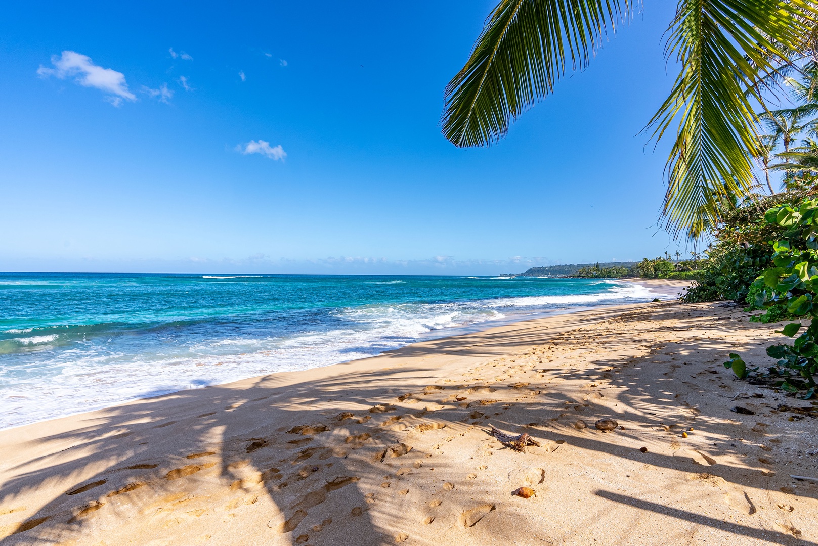 Haleiwa Vacation Rentals, North Shore Beachfront Resort - Sunlit beach with soft sand and gentle waves.