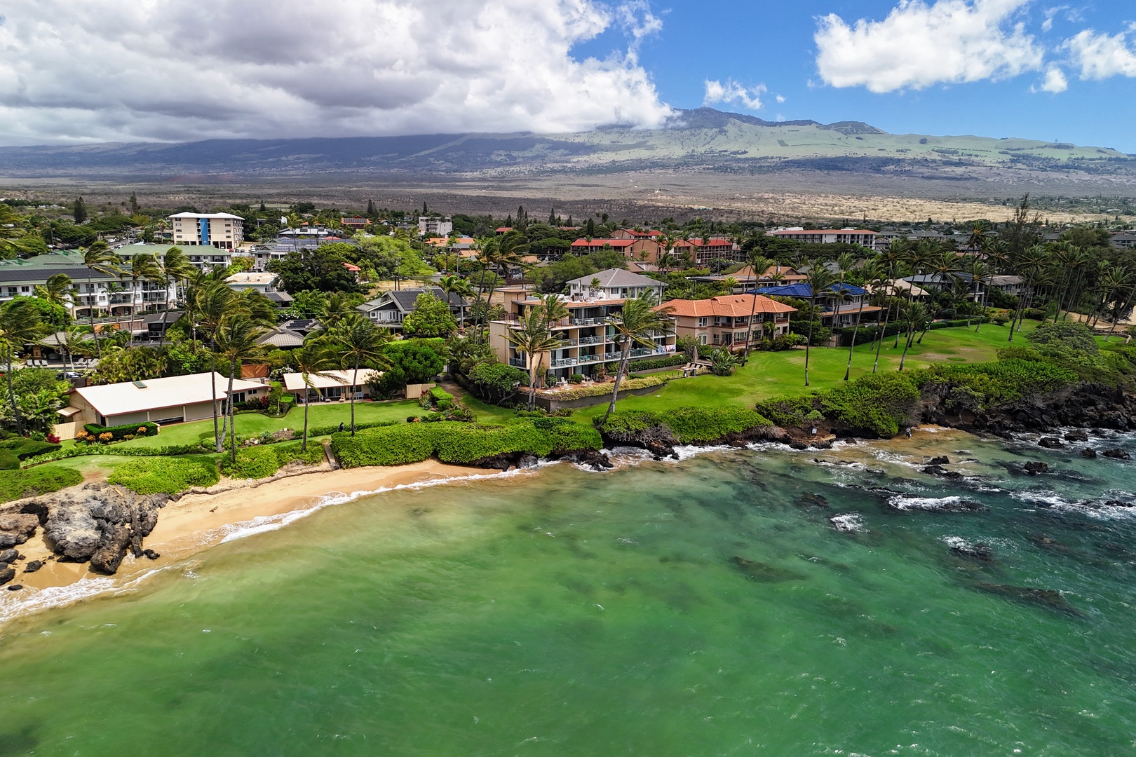 Kihei Vacation Rentals, Punahoa Beach 205 - A pocket beach tucks between lava points, with dry upland slopes rising in the distance.