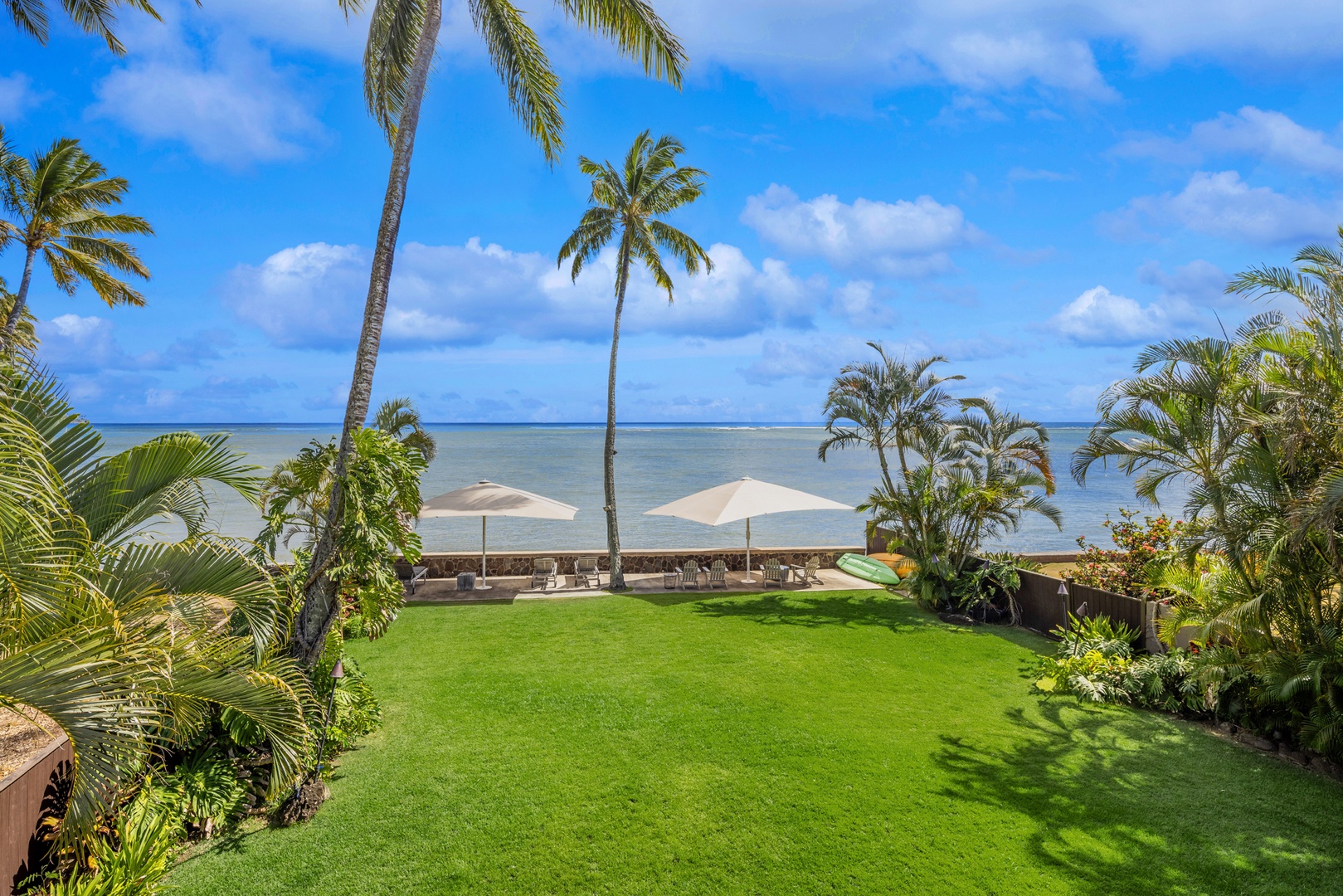 Honolulu Vacation Rentals, Moana Lani - Main House - A lawn big enough for an afternoon game of catch, with tall palms on either side.