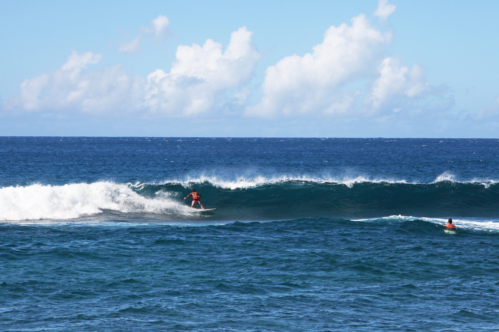 Koloa Vacation Rentals, Hale Ka Pua Ola at Kukuiula - Surfer riding the waves under clear blue skies.