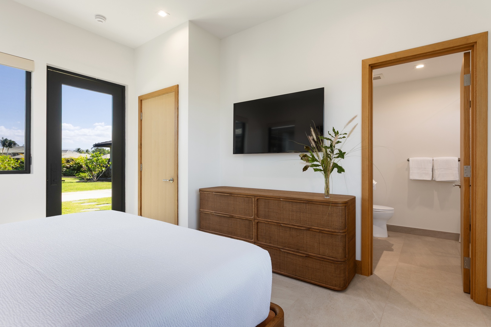 Kamuela Vacation Rentals, 5BD Mauna Lani Lux Ocean Estate (OE12) at One Ocean - (Bedroom 4) Your serene bedroom features crisp white linens, a wall-mounted TV for relaxation, and garden views through large windows.