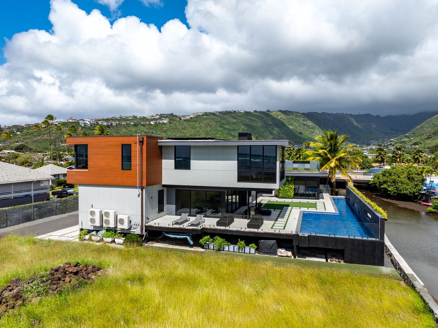 Honolulu Vacation Rentals, Ocean Villa 3 Bedroom - Striking modern villa with infinity pool set against lush coastal surroundings.