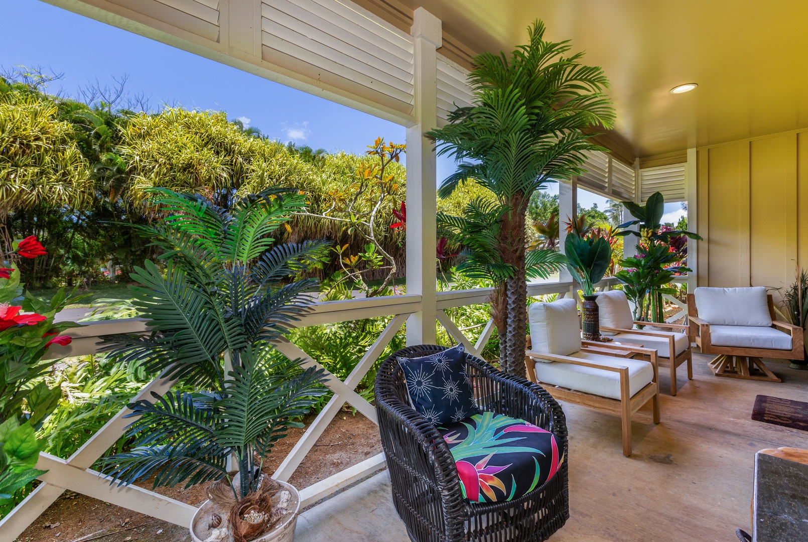 Princeville Vacation Rentals, Pualani Villa - Lounge on the covered patio, offering comfortable seating and lush garden views.