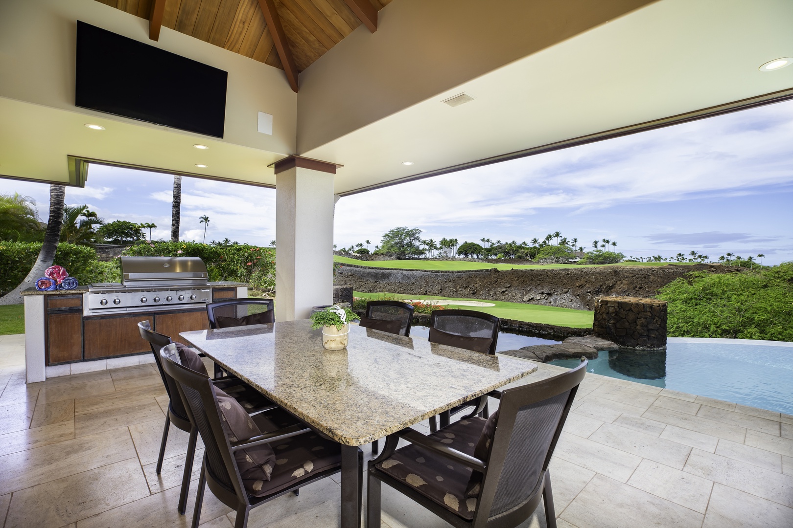 Kamuela Vacation Rentals, Champion Ridge 7 - Savor meals at your granite dining table while golf course views stretch beyond your infinity pool in this covered outdoor paradise.