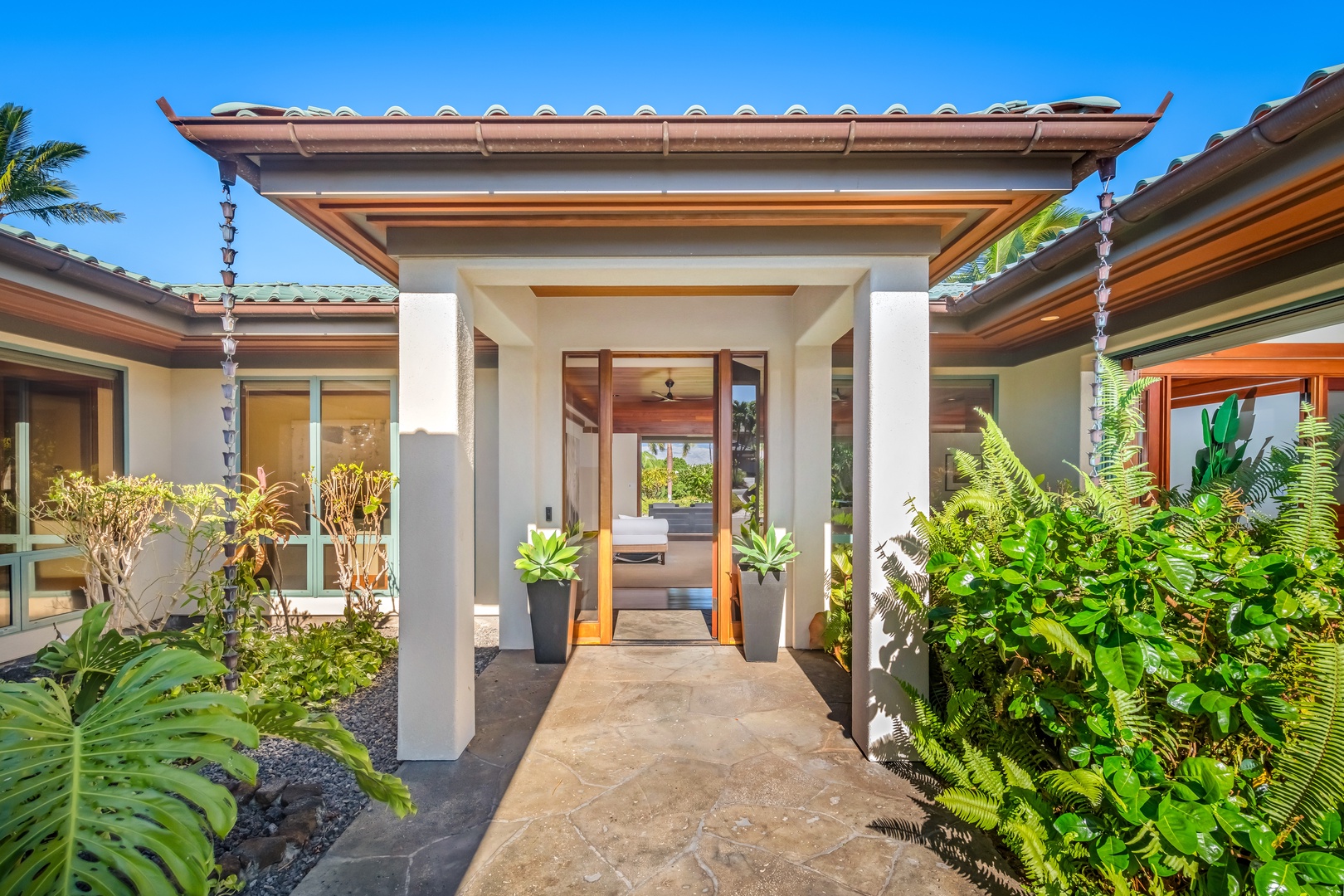 Kamuela Vacation Rentals, Champion Ridge Oasis - Grand entryway framed by tropical plants and a welcoming gated pathway.