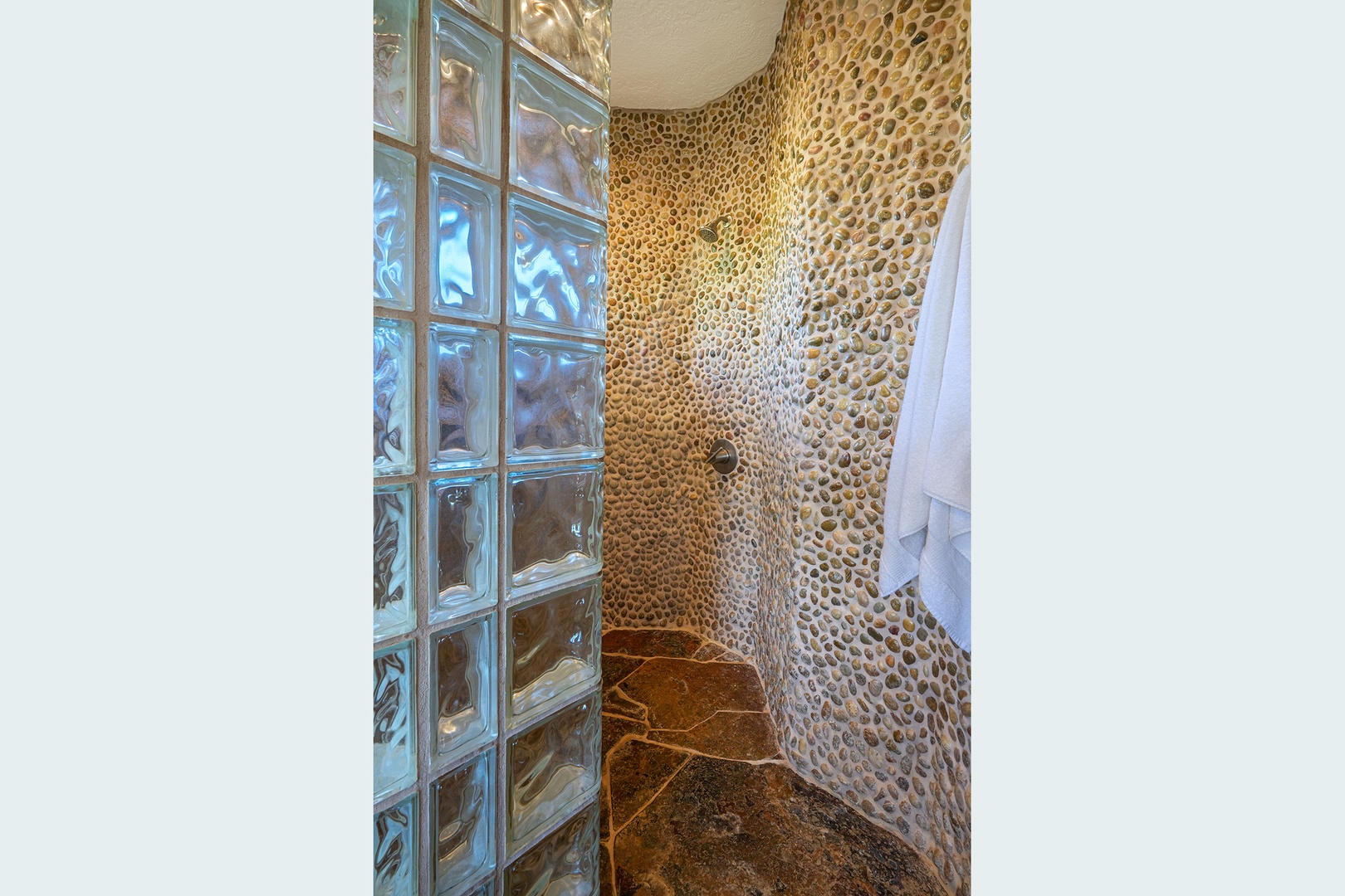 Princeville Vacation Rentals, Pohaku Villa - Step into your private spa-like shower featuring stunning pebble stone walls and glass block details for the ultimate relaxing retreat.