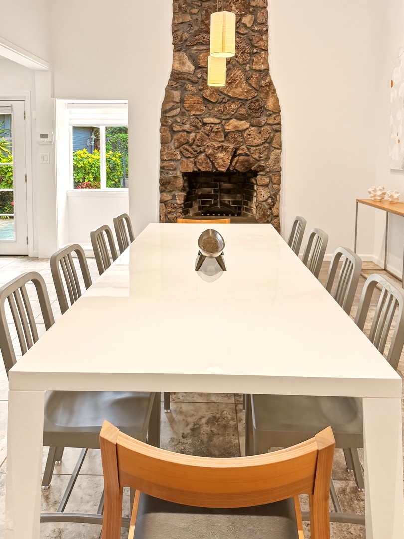 Honolulu Vacation Rentals, Ho'okipa Villa - Gather around this elegant dining table where meals become memories, with the warmth of a stone fireplace creating the perfect ambiance.