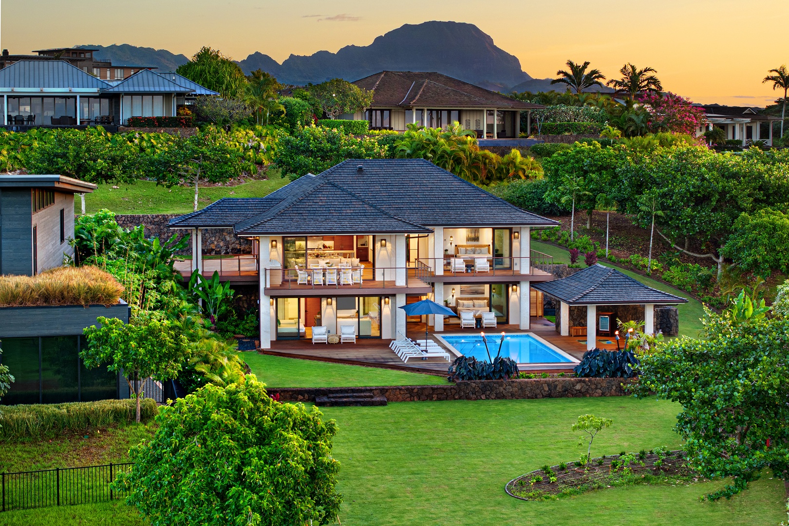 Koloa Vacation Rentals, Hale Kai‘opua at Kukui'ula - Sunset-lit aerial perspective of the home, highlighting lush surroundings.