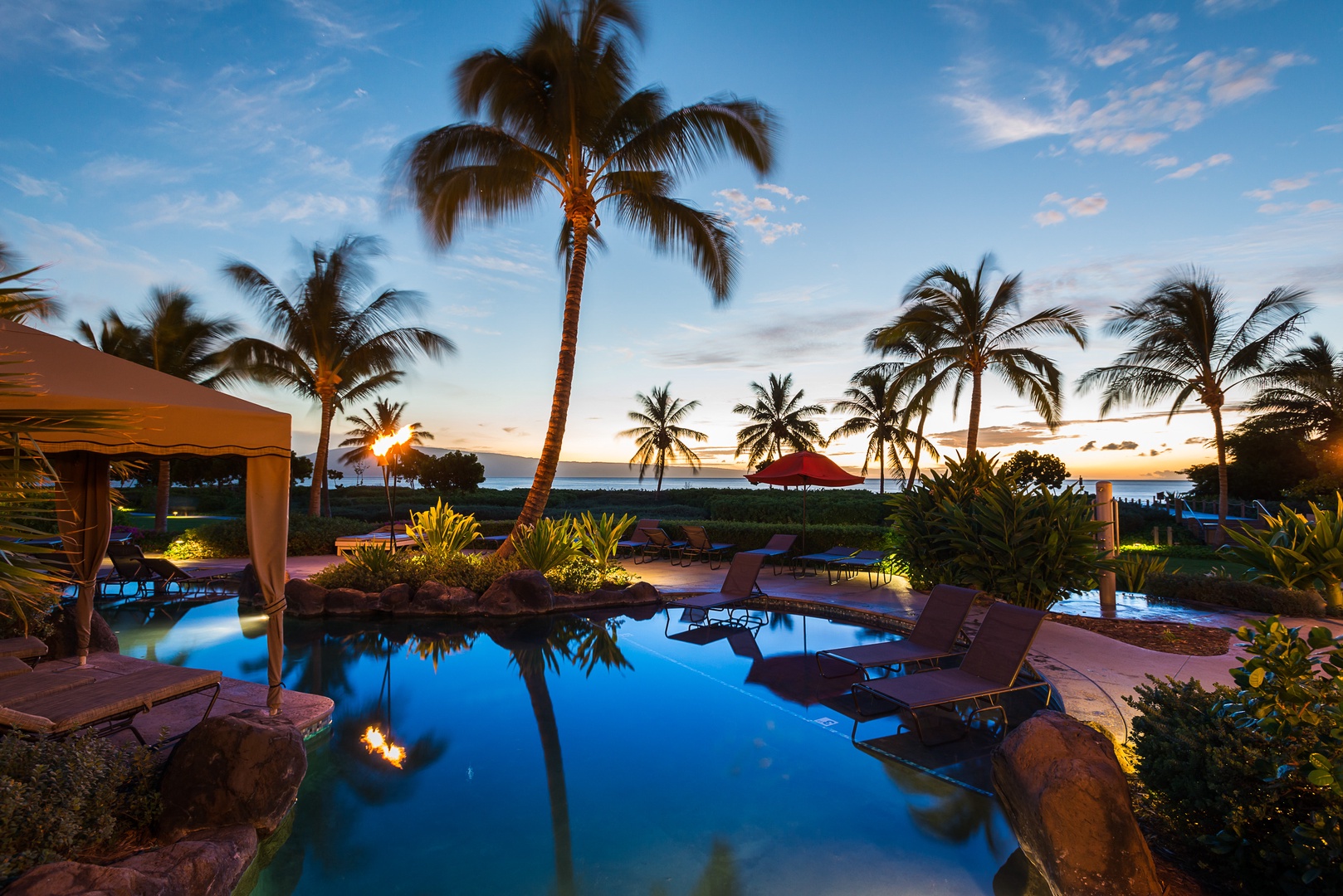 Lahaina Vacation Rentals, Honua Kai Konea 206 - This serene poolside setting at sunset is surrounded by swaying palm trees and a view of the ocean