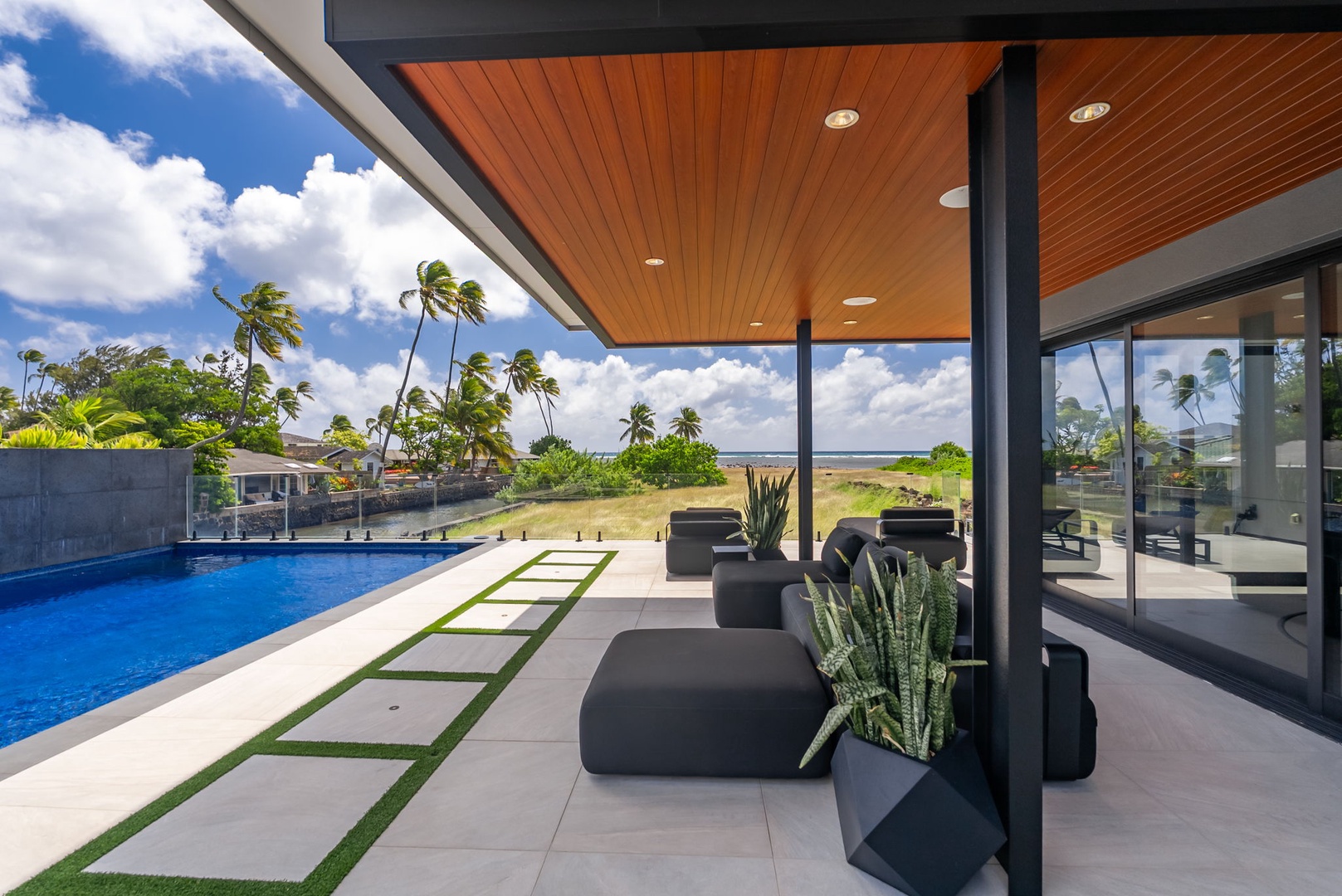 Honolulu Vacation Rentals, Ocean Villa Emilie - Lounge poolside beneath a sleek wood canopy, where modern design meets serene Hawaiian skies.