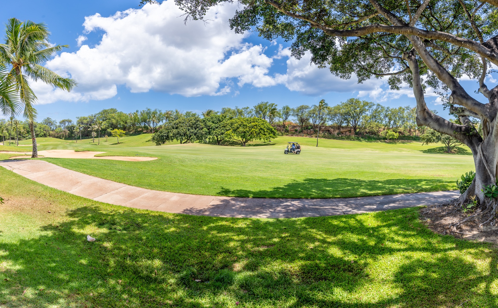 Kapolei Vacation Rentals, Fairways at Ko Olina 8G - Pristine golf course with lush fairways and tropical palm trees under a brilliant blue sky.