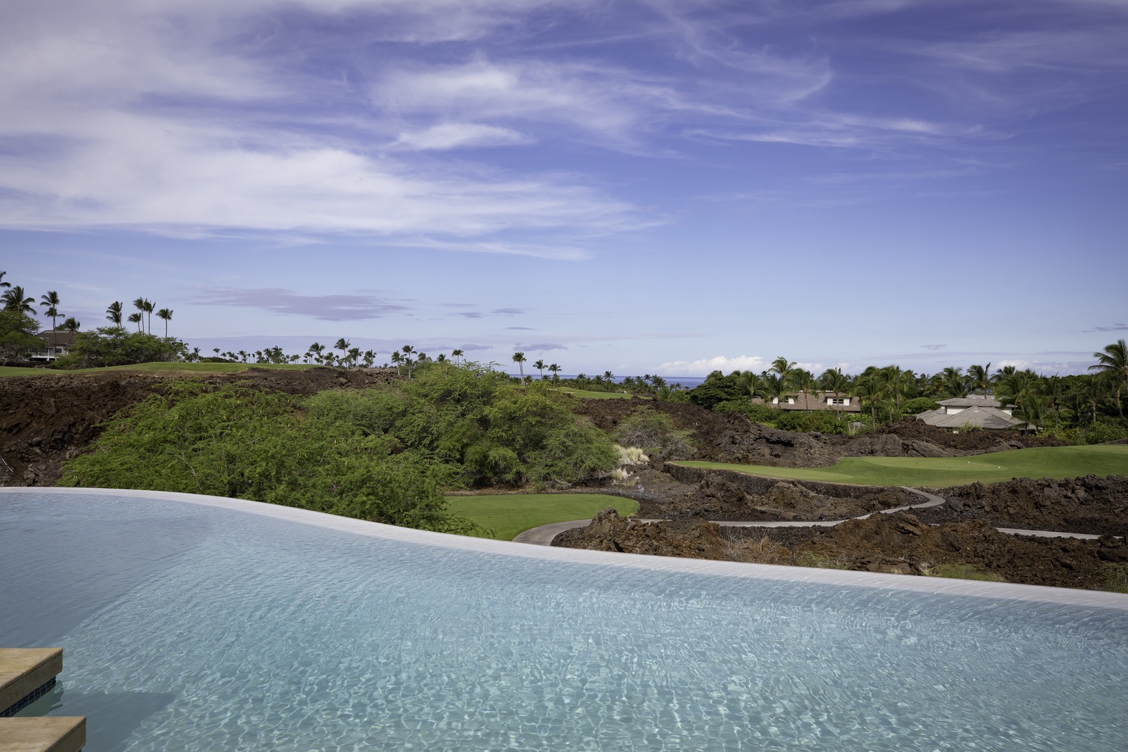 Kamuela Vacation Rentals, Champion Ridge 7 - Infinity pool overlooking lush golf course and tropical landscape beneath stunning Hawaiian skies.