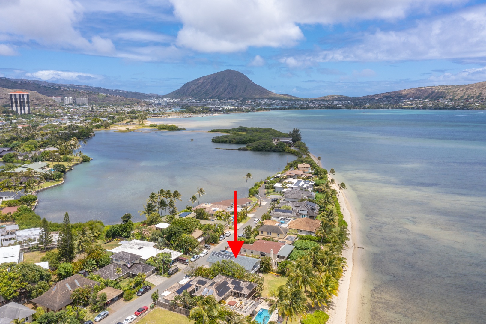 Honolulu Vacation Rentals, Honolulu Beachfront Retreat - Aerial perspective pointing to the property, surrounded by coastal beauty and lush hills.