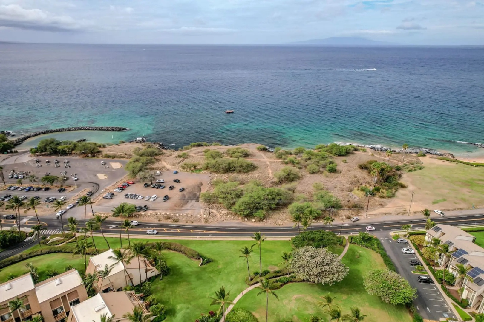 Kihei Vacation Rentals, Maui Kamaole E103 - The beach across the street draws a crowd, rock jetty and all, most afternoons.
