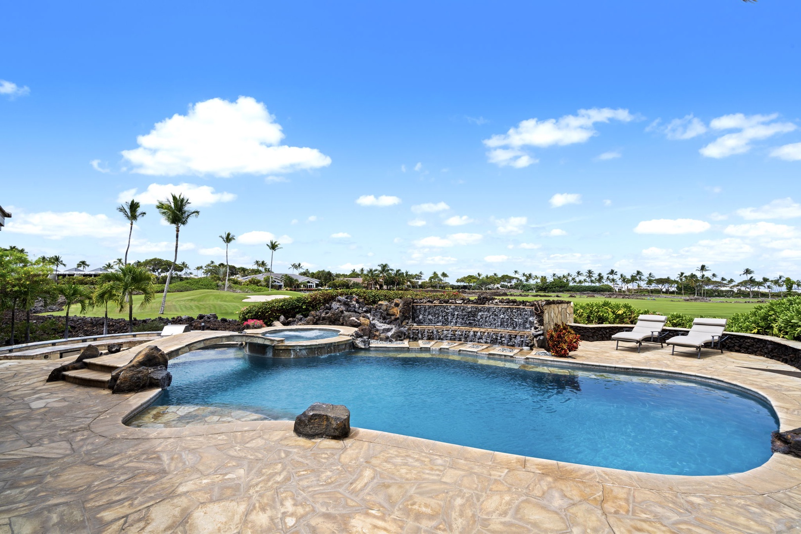 Kamuela Vacation Rentals, Hale Konane - Spacious pool with lava rock accents and palm-dotted views for tropical lounging.
