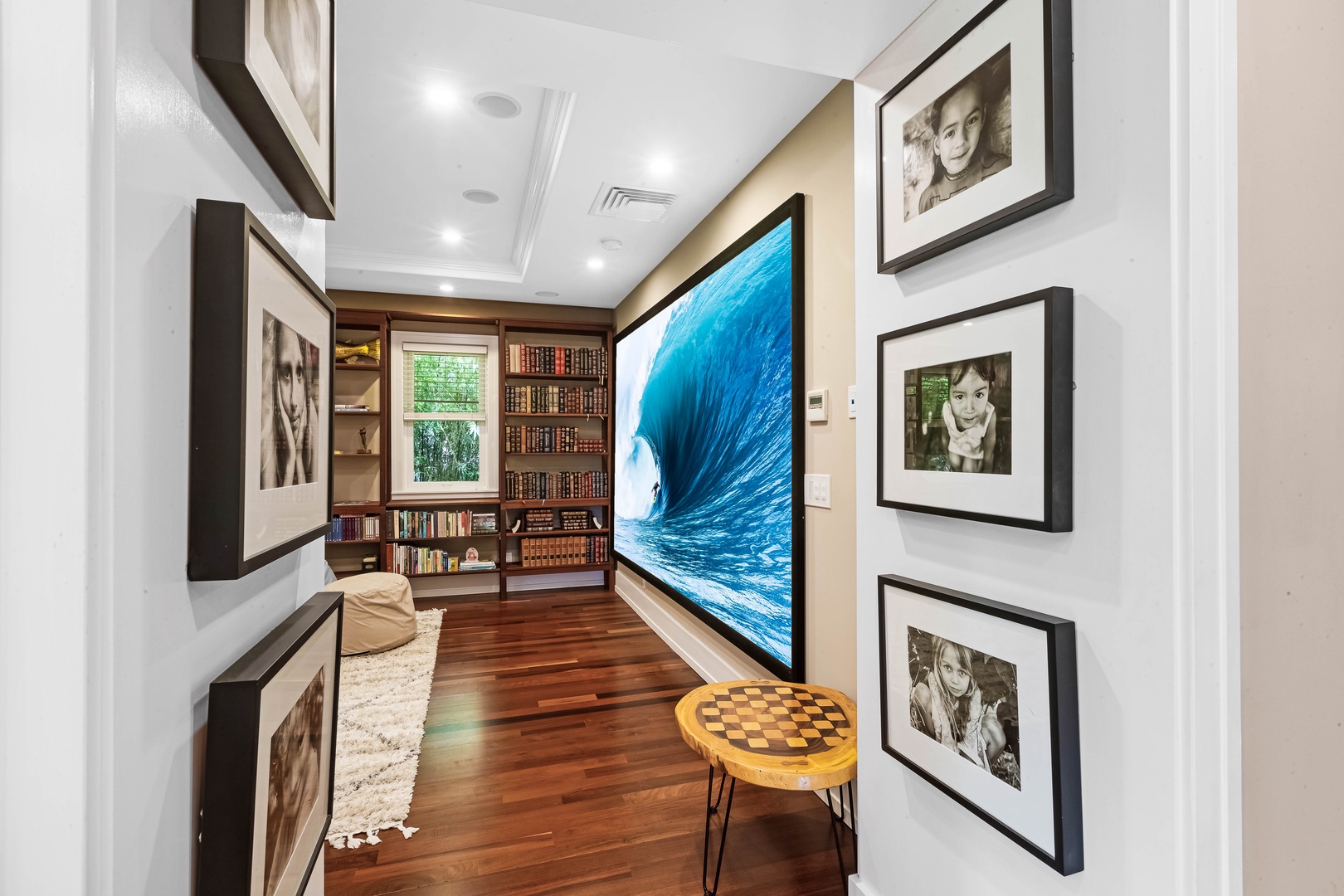 Honolulu Vacation Rentals, Pili Pono - Media hallway with ocean wave projection and art-lined walls.