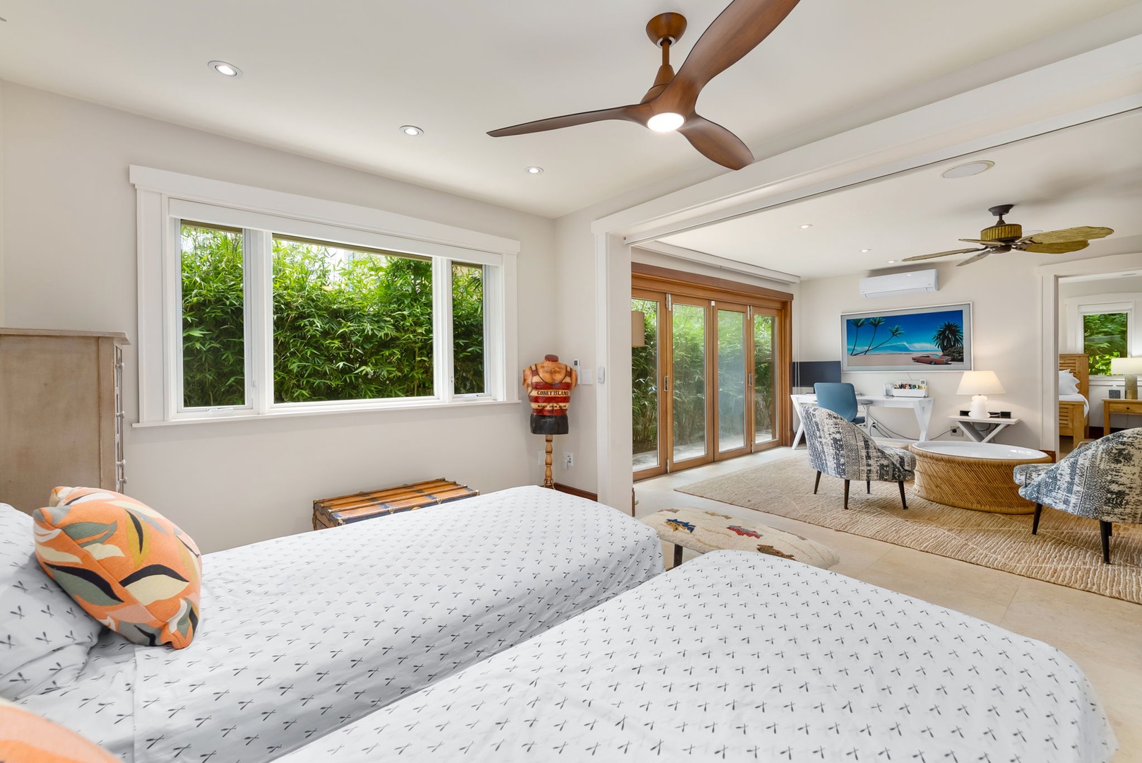 Kailua Vacation Rentals, Leaf House - Lounge in your bright, spacious suite with plush beds, tropical-inspired décor, ceiling fans for gentle breezes, and a connecting sitting area overlooking lush greenery through floor-to-ceiling windows.