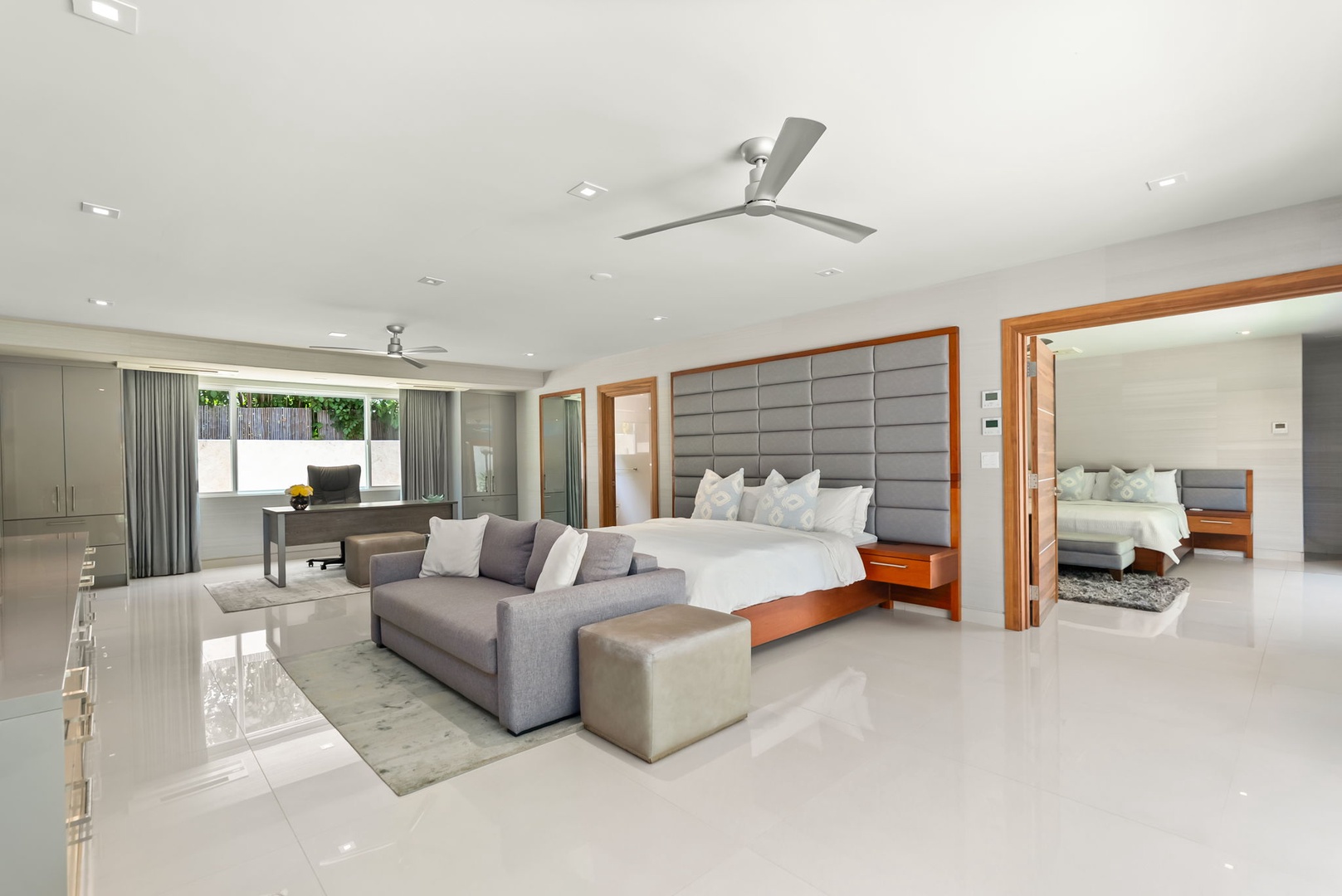 Honolulu Vacation Rentals, Diamond Head Beachfront Estate - Step into your bright, contemporary suite where sleek white tile floors and a plush king bed create a modern sanctuary. Relax on the stylish sectional, enjoy dedicated workspace, and open connecting doors to expand your space.