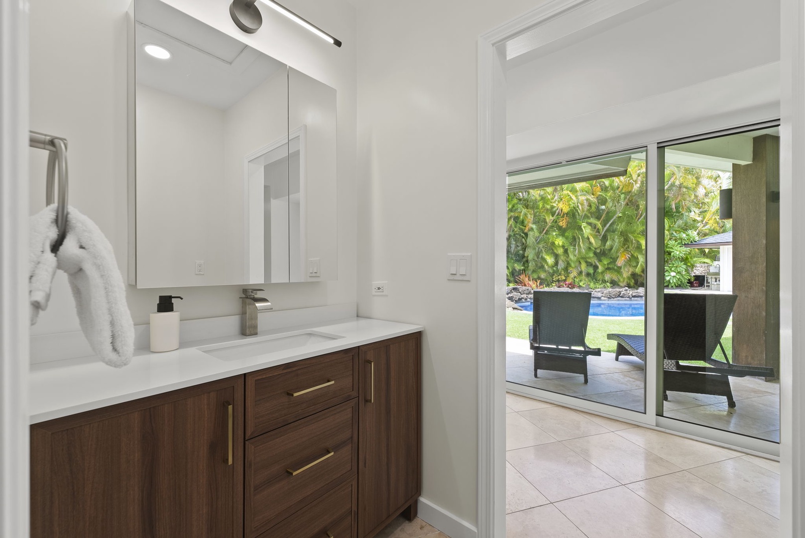 Honolulu Vacation Rentals, Kahala Lani - Modern bathroom with clean finishes and pool views through sliding glass doors.