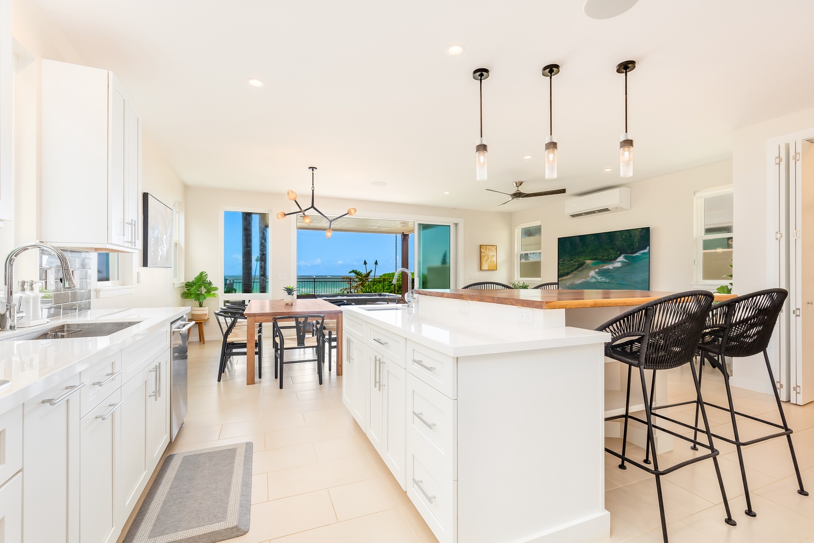 Laie Vacation Rentals, Majestic Mahakea Oceanfront Oasis - Full view of the modern kitchen, dining, and living spaces, showcasing the airy design.