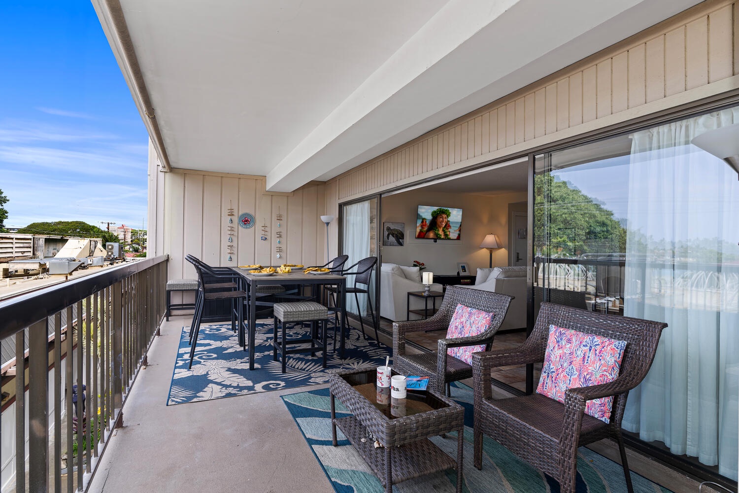 Kailua Kona Vacation Rentals, Kona Plaza 201 - Your spacious lanai blends indoor comfort with outdoor dining, featuring wicker seating and panoramic views perfect for morning coffee or evening meals.