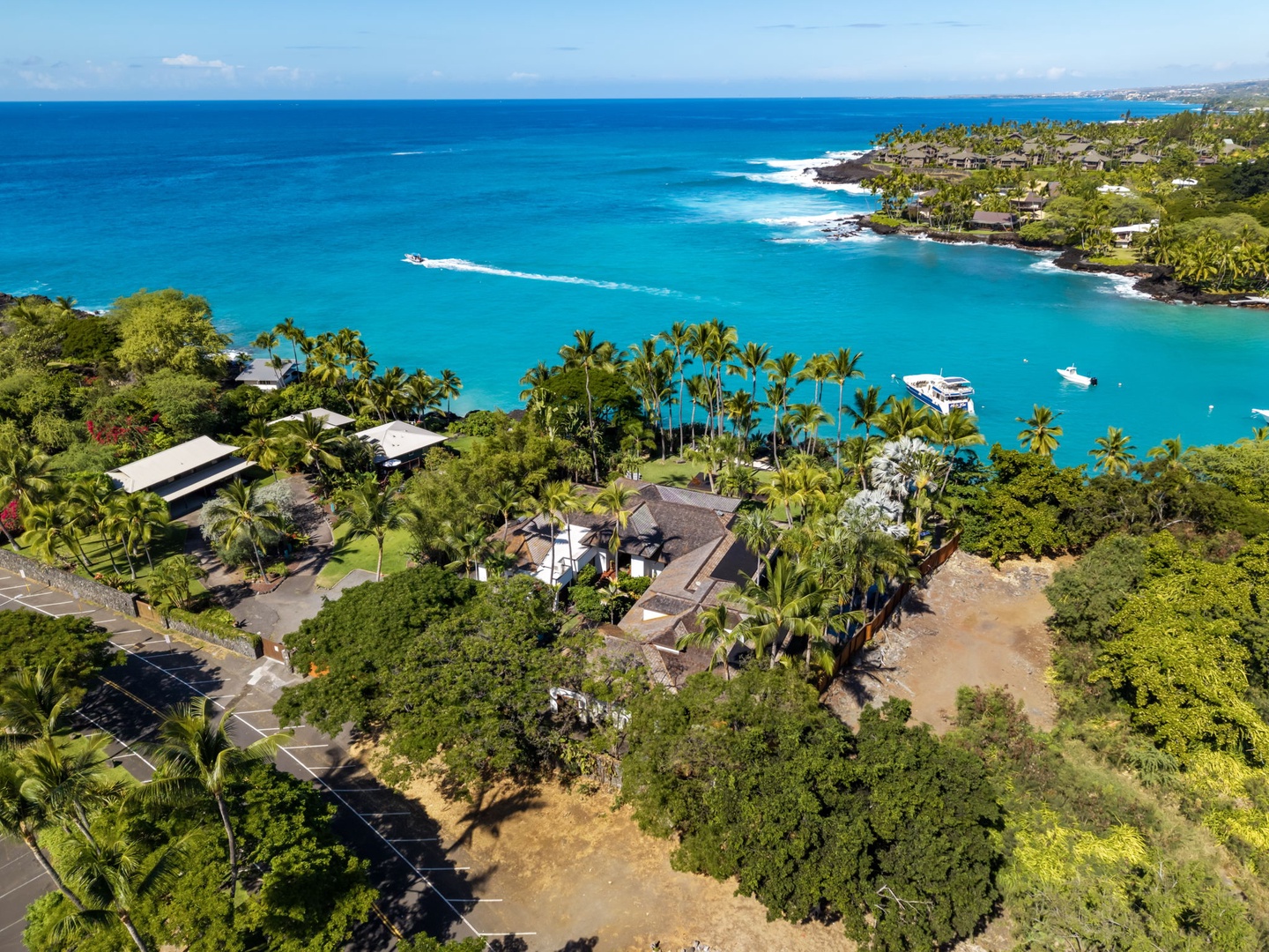 Kailua-Kona Vacation Rentals, Hahalua Bay Villa - Stunning aerial view of oceanfront properties nestled among tropical palms along pristine turquoise waters and white sandy beaches.